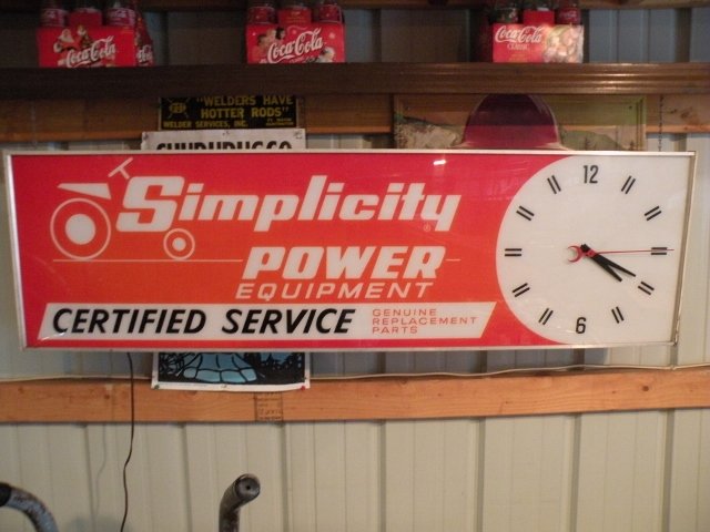 Lighted Simplicity Lawn & Garden Clock Sign: Advertising clock measures 50" wide x 15" tall x 5.5" deep. A great display piece for any garage. Simplicity power.