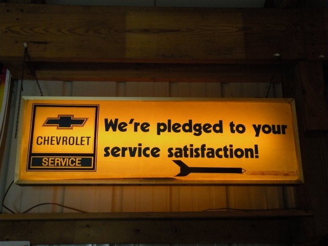 Chevrolet Lighted Auto Service Ad Sign: "We're pledged to your service satisfaction." A great collectable Chevy lighted sign. Perfect for any garage or hobby shop. Sign measures 38.25" by 12" by 5". Double sided.