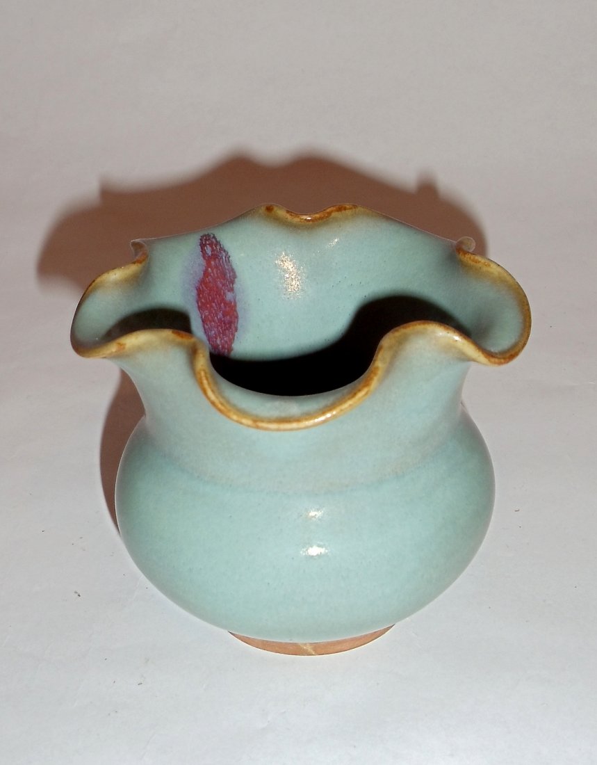 A Junyao-Styled Floral-Shaped Zun with a Rosy Splash: This zun-pot, elegantly shaped like a flower, is glazed in sky-blue. It bears an artistic rosy pattern inside which is an accidental result during its firing. Its foot-rim is unglazed. Height: ４