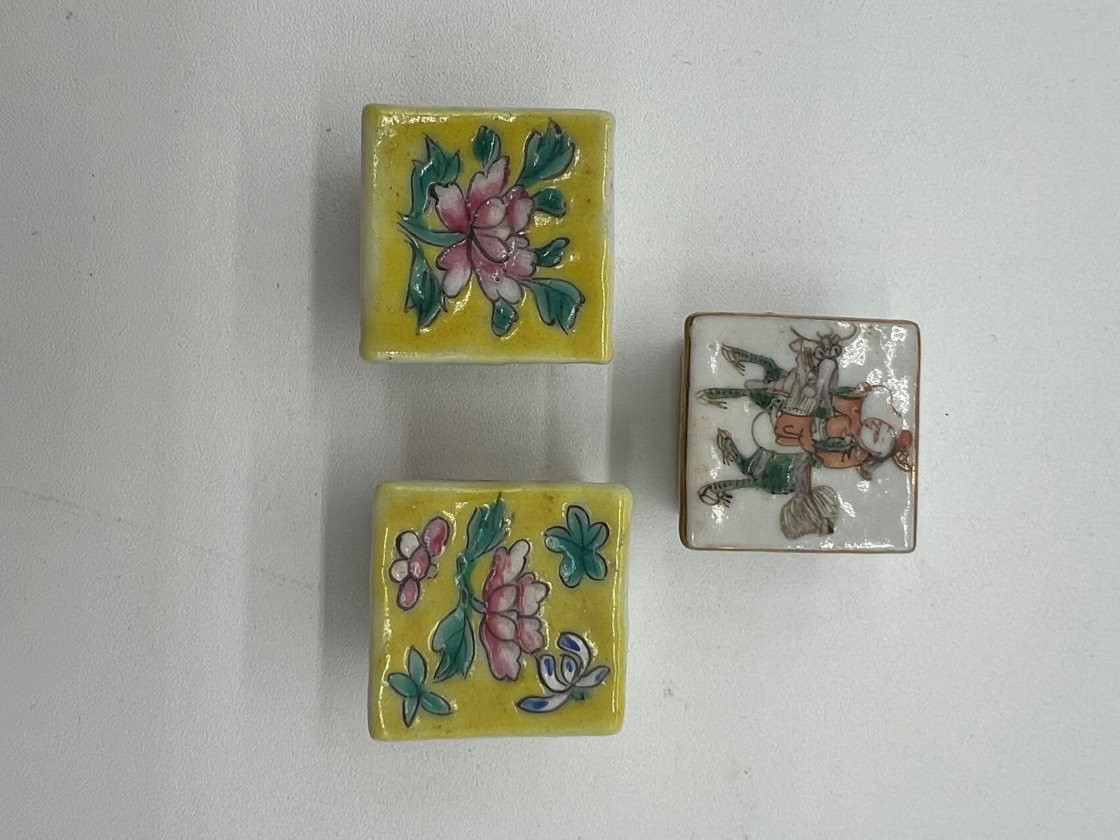 Set of three Antique Chinese porcelain pill boxes: Qing dynasty (1644-1912);The two with the yellow background and pink flower. Each box : 1 x 1 x 1 inch