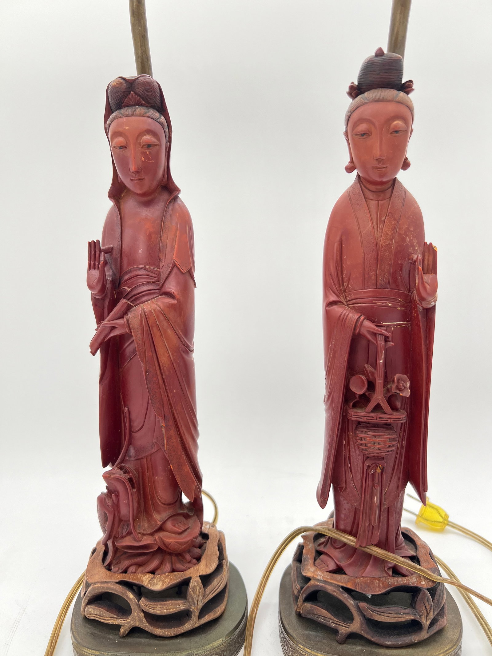 A pair of Chinese sculptures lamps: 19th century; a pair of sculptures that appear to depict serene figures in traditional robes, possibly representing Buddhist or Eastern deities or figures.