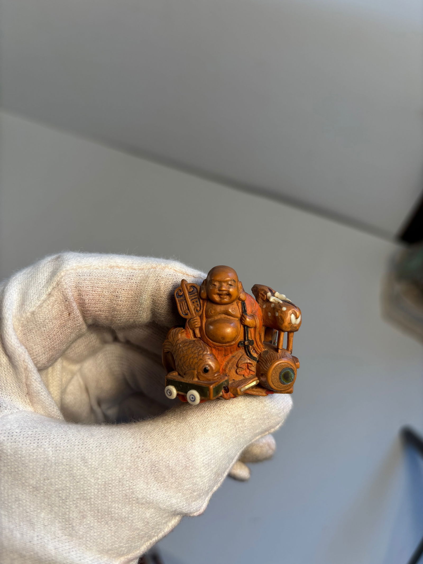 A boxwood and mixed -media inlay netsuke of Hotei (1 of 11)