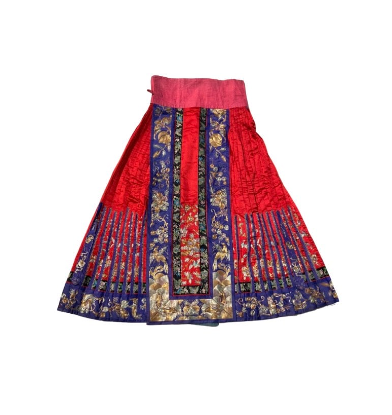 A Chinese Woman’s embroidered Pleated Skirt (Mamianqun): Qing dynasty(1644-1912);A finely crafted Chinese woman’s silk mamianqun (horse-face skirt). The skirt is composed of red silk with deeply pleated side panels and alternating vertical bands of cobalt