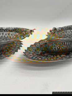 A set of Chinese Famille Rose reticulated porcelain basket and plate: Qing Dynasty (1644-1912); This set has a detailed, colorful enamel decoration, with what looks like a combination of floral and geometric patterns around both the basket and the plate. The handles on