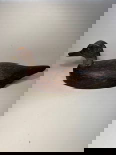 American Hand-Carved Wooden Duck Decoy with Carved Feather Detail: Early 20th century, A finely hand-carved wooden duck decoy, American, early 20th century. The body features deeply incised feather detailing and a separately attached head with traces of original pain