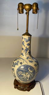 A Chinese blue-and-white Chinese porcelain vase lamp: Qing dynasty (1644–1912); The vase has a deliberate crackle finish glaze. The vase depicted in the photo features a traditional blue-and-white design with scenes of figures under a pavilion or in a