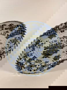 A Large Chinese blue and white porcelain plate: Kangxi (1662–1722), Central flower basket motif, symbolizing prosperity and abundance.Four outer reserves with floral sprays alternating with lattice diaper patterns.Classic cobalt blue underglaze d