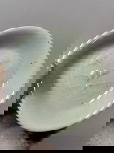 A Chinese celadon-glazed dish with MARK  'WAN LI NIAN ZHI': Qing dynasty(1644-1912); Chinese celadon-glazed porcelain dish featuring an impressed floral design at the center, covered with a soft green translucent glaze in the Longquan tradition with MARK 'WAN