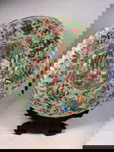 A Super Large Chinese Famille Rose Plate with Hundred Treasures and Celadon-Glazed Back: Qing Dynasty (1644-1912); with a rare celadon-glazed reverse and richly decorated famille rose front. The central medallion depicts a lively court scene with elaborately robed figures in a garden pavi