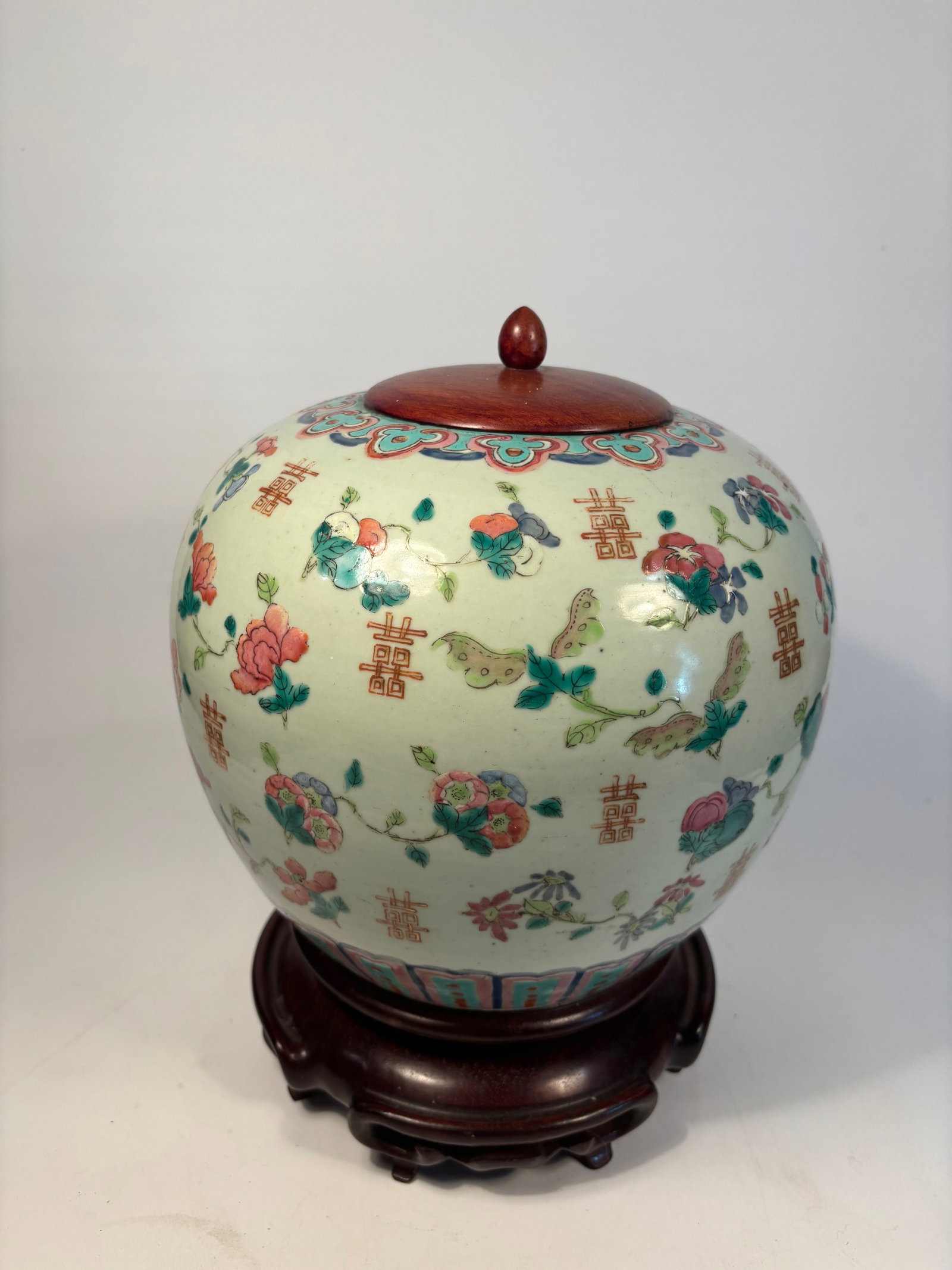 A Famille Rose ‘Butterfly and Flower’ Jar with Wood Cover: Qing Dynasty (1644-1912); The ovoid porcelain jar is finely enameled in the famille rose palette with colorful butterflies fluttering among peony, chrysanthemum, and hibiscus blooms, all interspersed 
