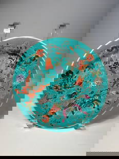 A Chinese famillie rose porcelain plate: A finely enameled Chinese porcelain plate decorated in the famille rose (fencai) palette on a vibrant turquoise ground. The central design features phoenixes, symbolic of beauty and renewal, surrounde