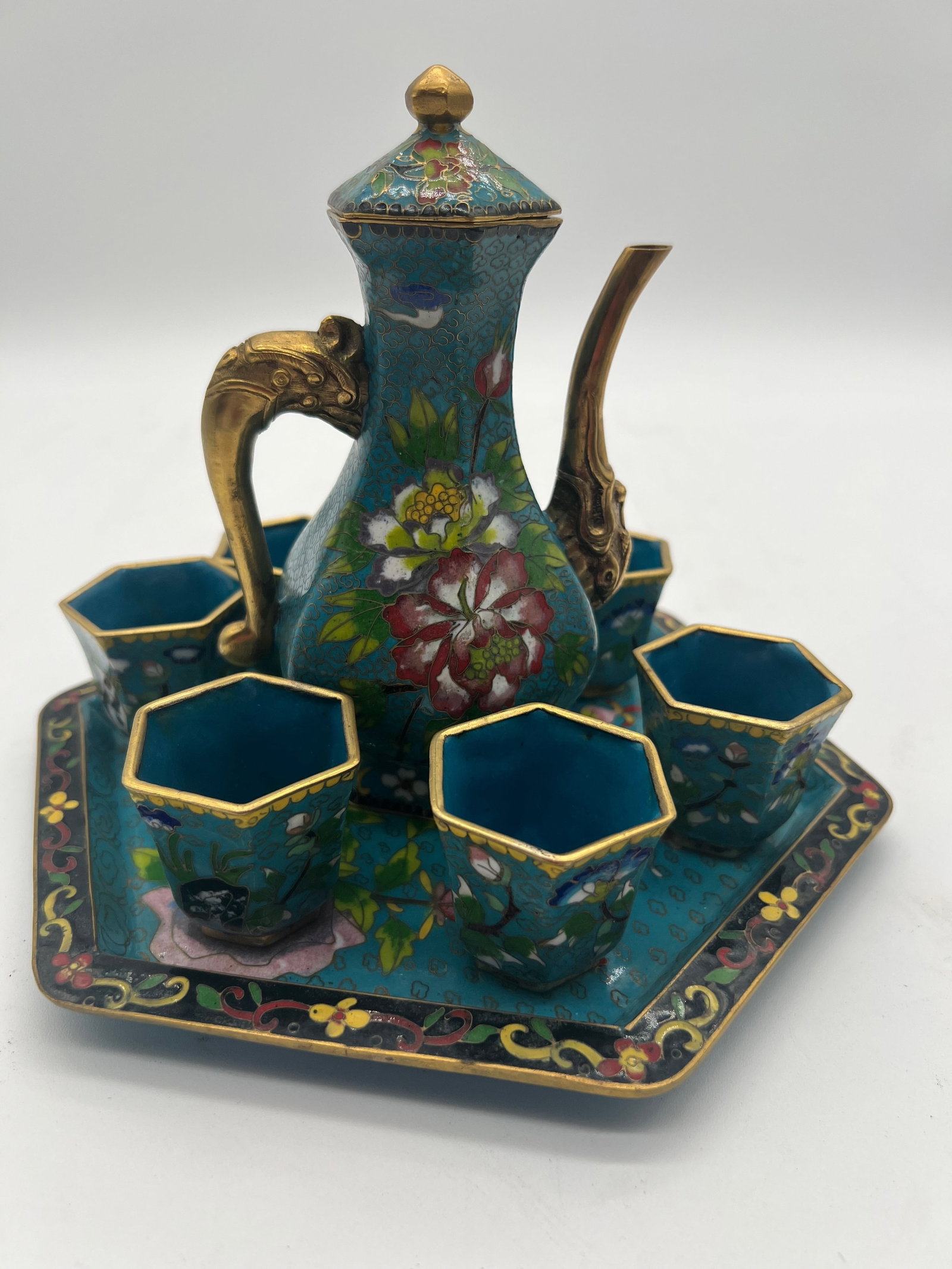 A Chinese cloisonné teapot with 6 gilt cups and plate: Early 20th , teapot height: 6 inches; Plate length: 8.5 inches