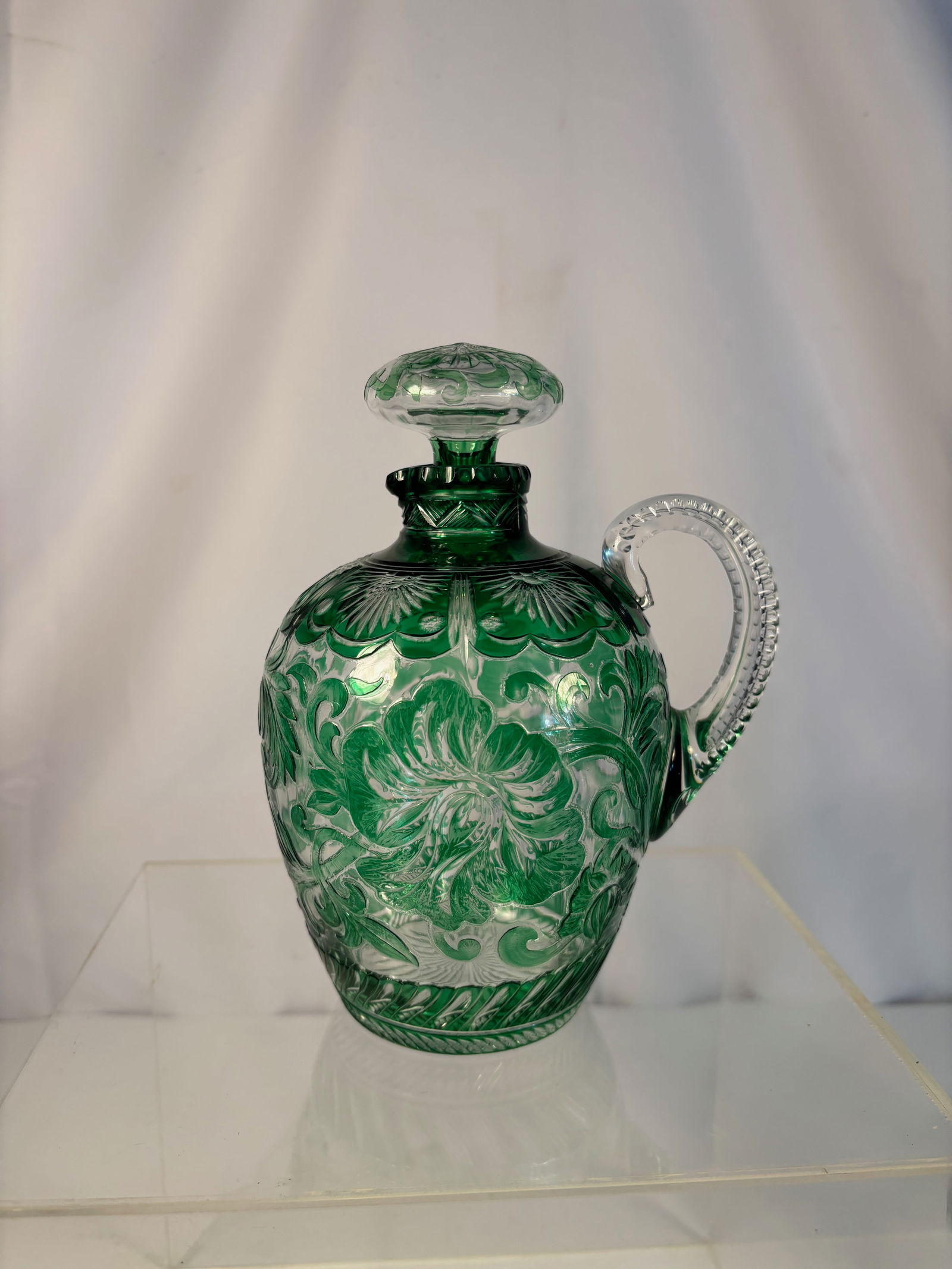 A Stevens & Williams Stourbridge Green Cut Crystal Jug with Starburst Stopper, c. 1890–1910: A fine Stevens & Williams Stourbridge Green Cut Crystal Jug, circa 1890–1910. The body of rich emerald-green lead crystal, wheel-cut with radiating star and petal motifs, and fitted with a matching