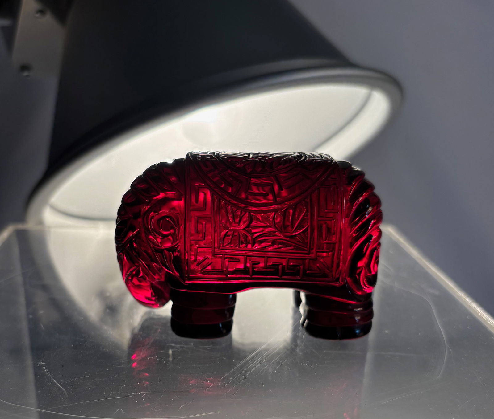 A Carved Cherry-Ambre Bakelite Elephant — Vintage Figural Sculpture: A vintage carved cherry-amber Bakelite elephant sculpture, featuring rich translucent red coloration and finely molded detailing. The piece shows the classic warm gloss and surface patina associated w