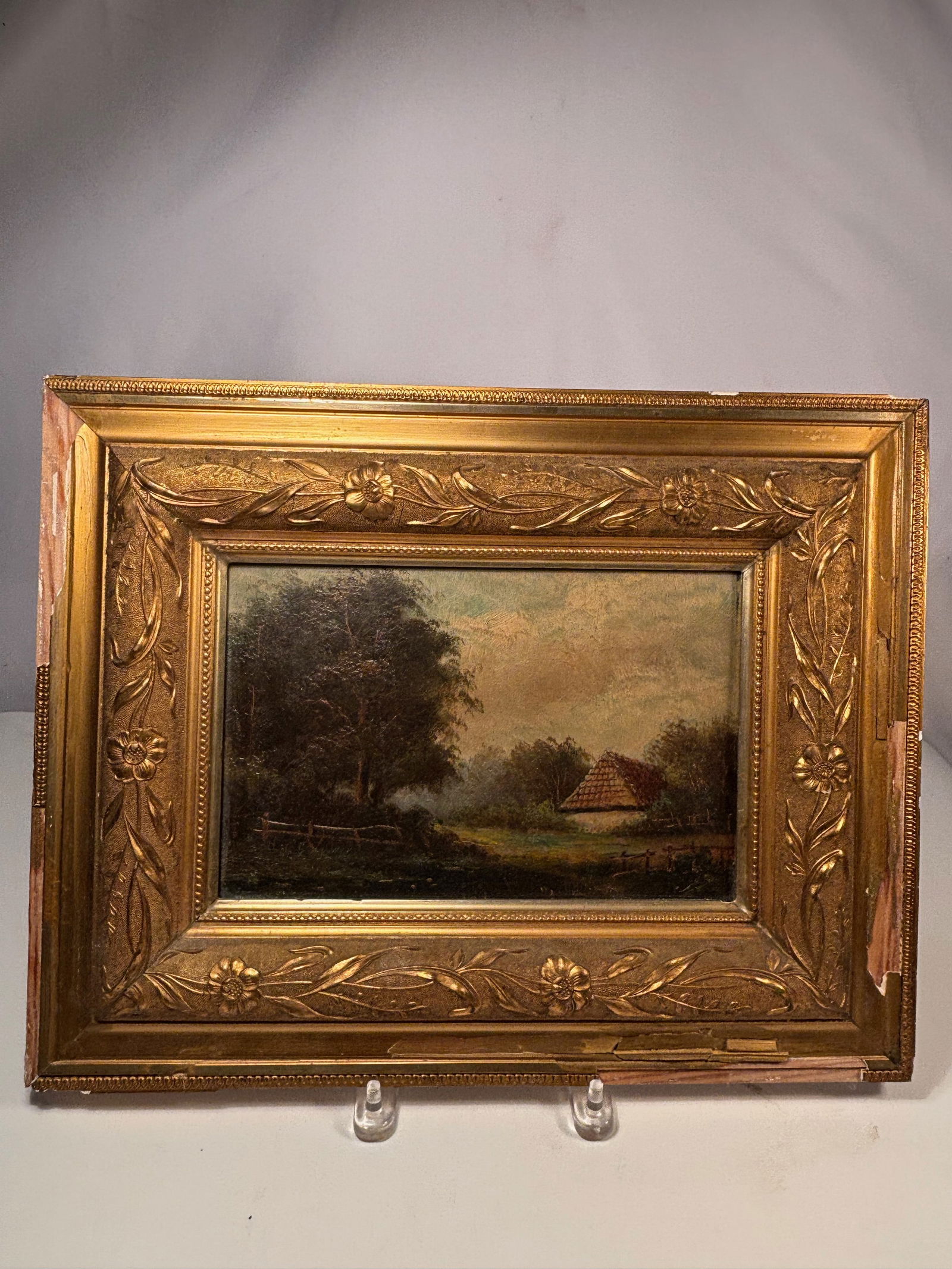British School (19th Century) Woodland Cottage by a Pond , Oil on canvas, framed: 19th century (c. 1850–1880); A serene pastoral landscape depicting a cottage nestled among dense trees under a soft golden sky. The artist’s technique shows layered brushwork and subtle modulation