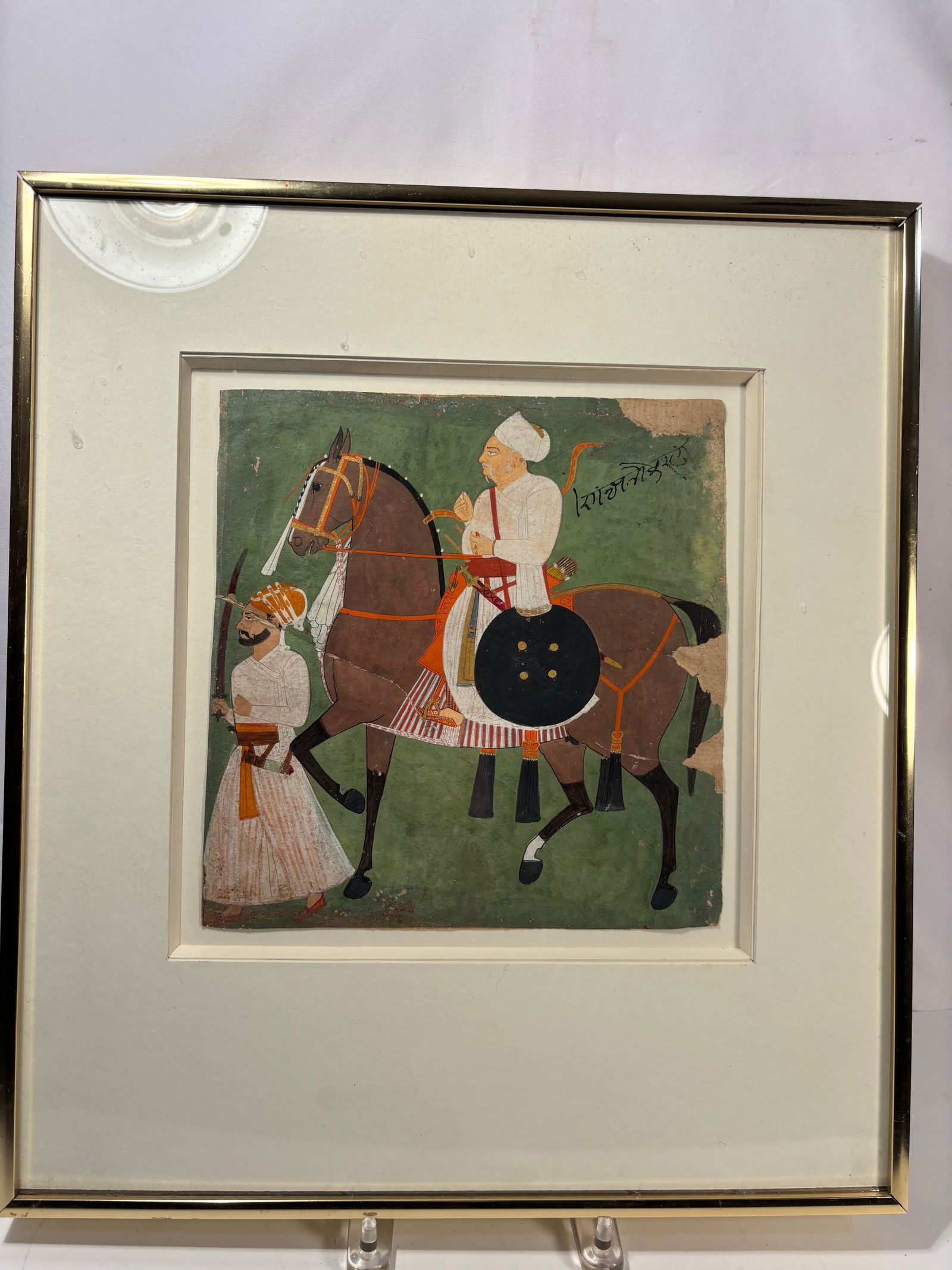 An Indian Miniature Painting of a Nobleman on Horseback: 19th century; An antique Indian miniature painting depicting a nobleman on horseback, attended by a standing servant. Rendered in opaque watercolors on paper, the composition features a richly caparis
