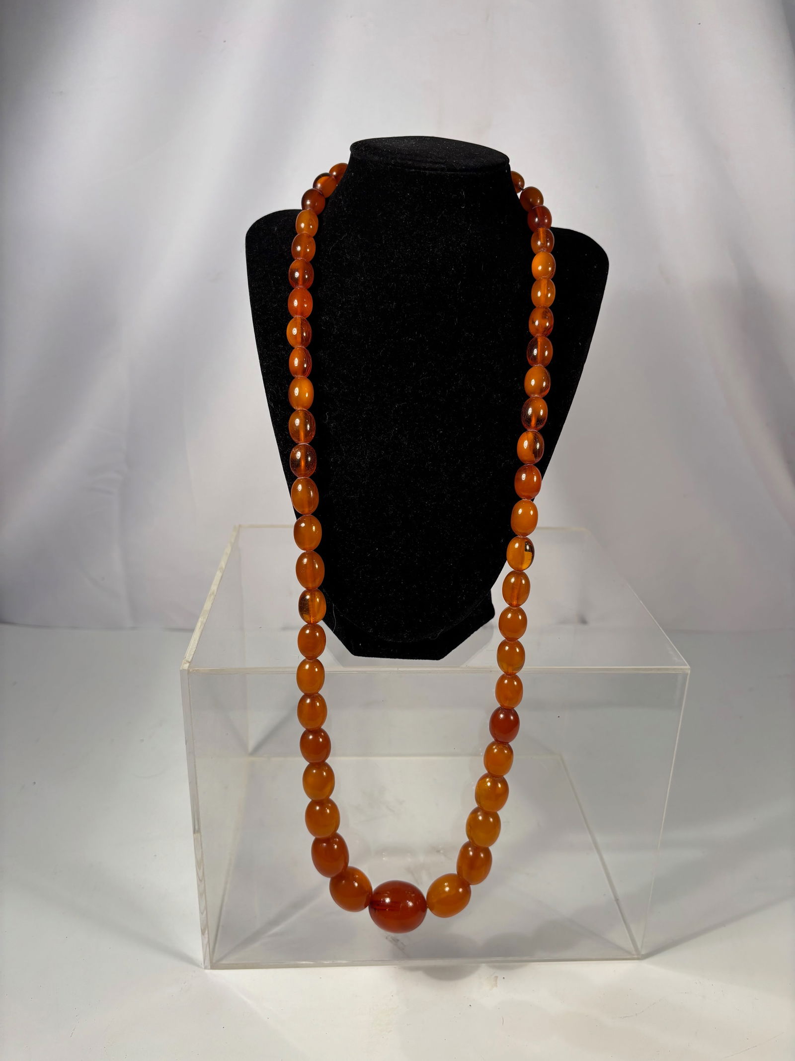 A Strand of Graduated Amber and Beeswax Amber Beads Necklace, 88gram ; Largest Bead Length: 28.5 mm: A long necklace composed of graduated oval beads in amber and beeswax amber (??), displaying rich tones from translucent honey and cognac to warm opaque yellow-brown. The beads show natural inclusions
