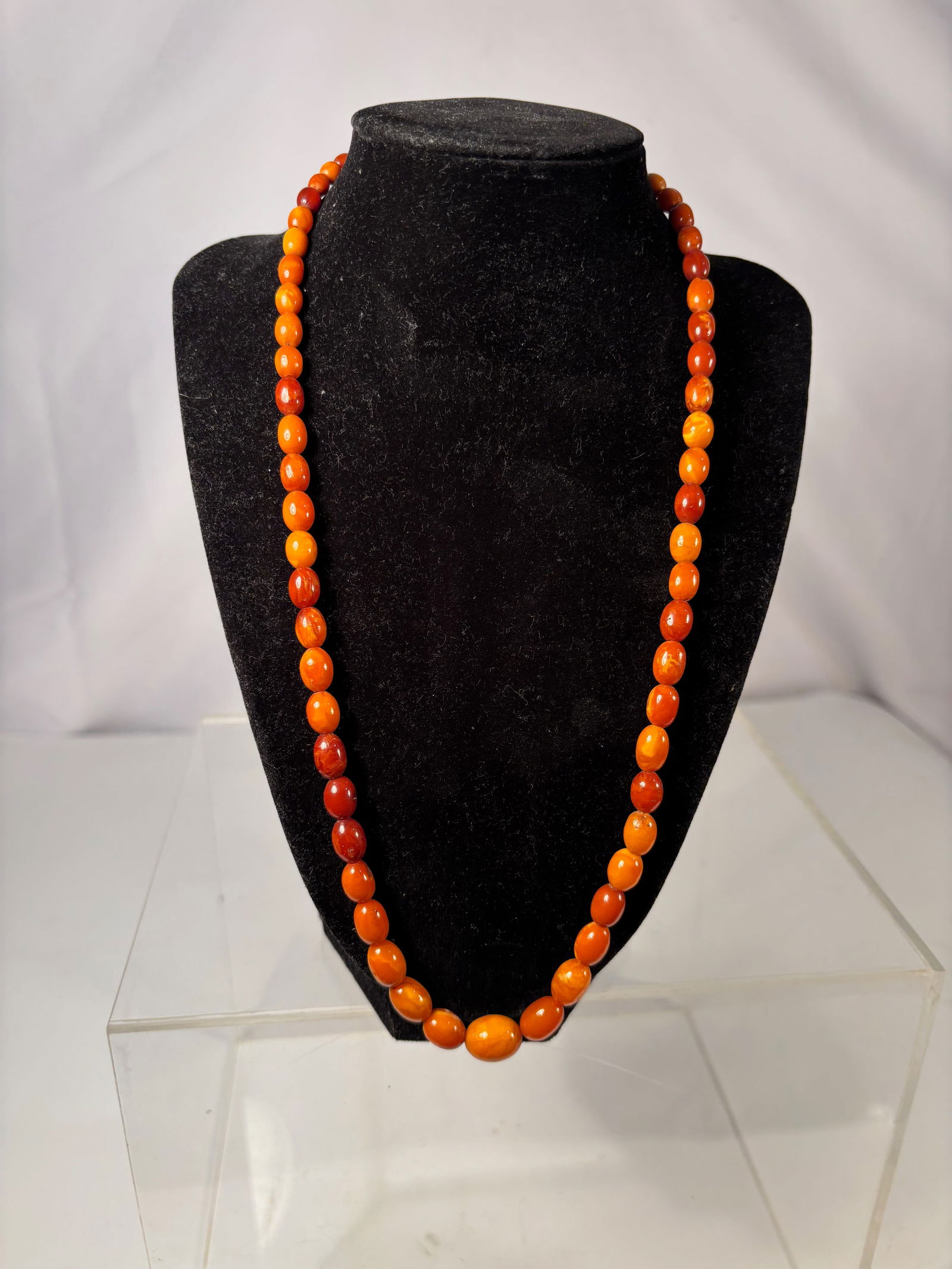 A Butterscotch Amber Bead Necklace with Graduated Beads: Vintage butterscotch amber bead necklace, dating to the early to mid-20th century. The strand is composed of graduated oval and barrel-shaped beads exhibiting classic opaque to semi-opaque butterscotc