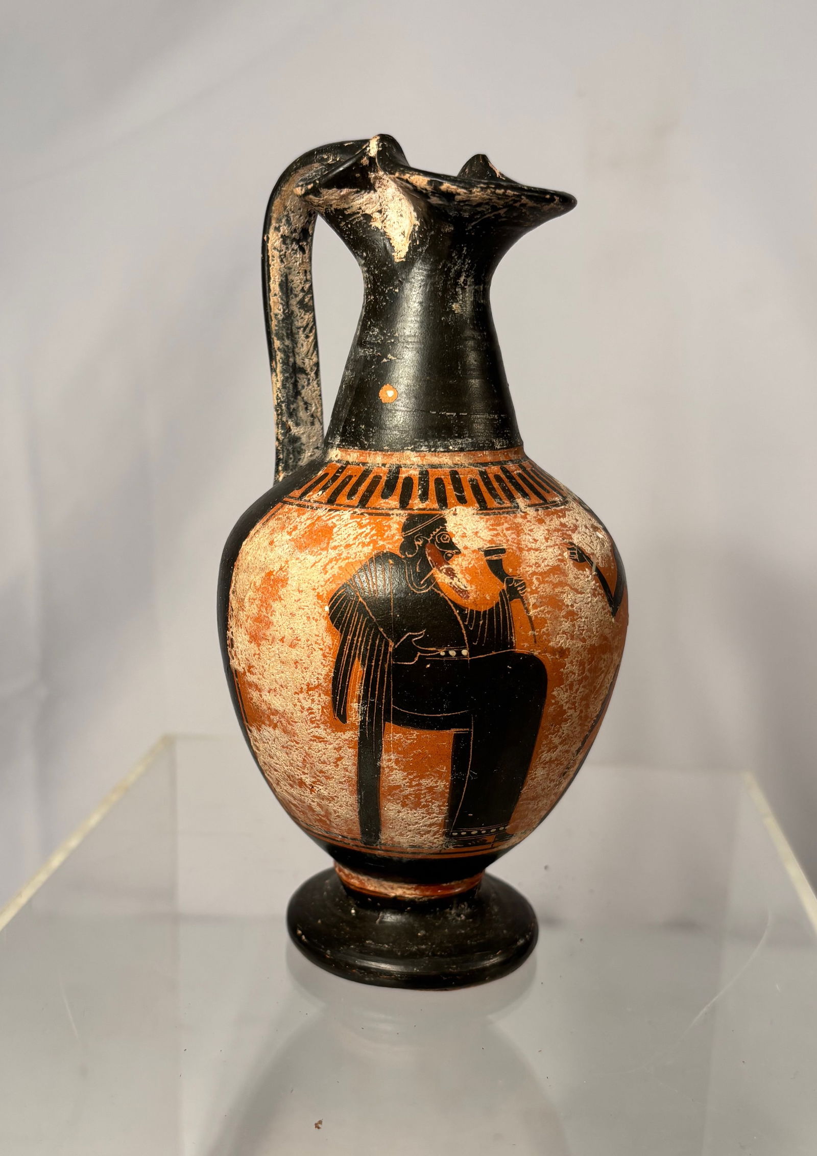 Greek Black-Figure Terracotta lekythos (oil flask): Greek black-figure terracotta lekythos (oil flask), decorated with a classical warrior figure in the Attic black-figure tradition. The vessel features a trefoil mouth, slender neck, rounded body, and