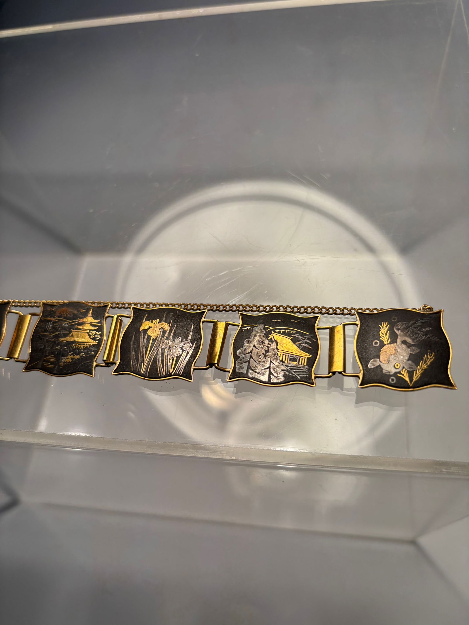 Japanese Damascene Shakudo Bracelet with Birds and Floral Panels: A vintage Japanese Damascene shakud? bracelet composed of multiple curved-panel links, each finely decorated with gold and silver inlay depicting traditional motifs—including bamboo, floral sprays,