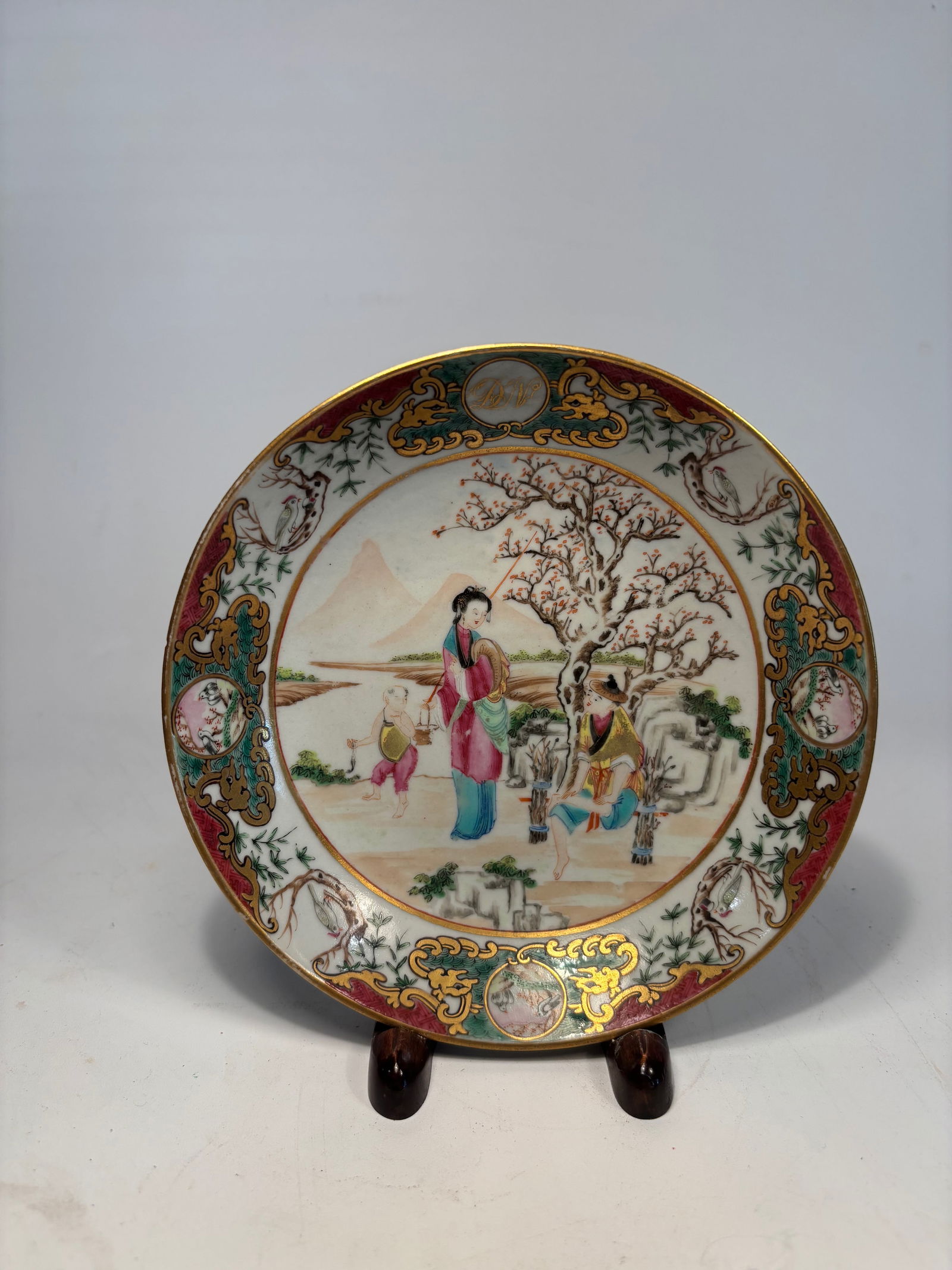 A Chinese Famille Rose Porcelain Plate with Figures,: Qianlong Period (1736–1795); A finely painted Chinese famille rose porcelain plate, dating to the Qianlong period (1736–1795). The central reserve depicts an elegant court scene with a noble lady