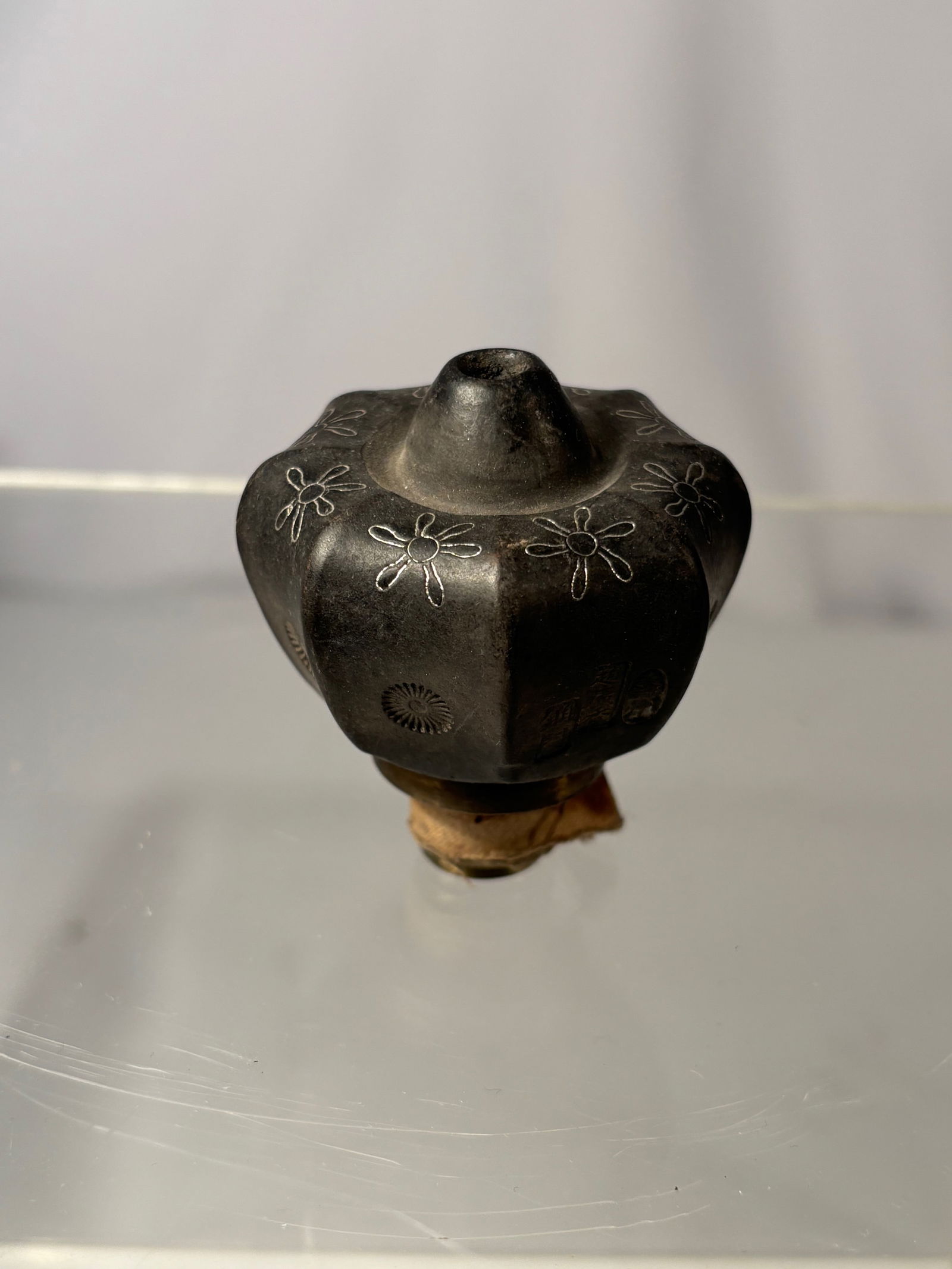 A Chinese Yixing Pottery Opium Pipe Bowl with Silver Inlay, Bronze Collar, and Maker’s Mark: Late 19th to early 20th century; A Chinese Yixing pottery opium pipe bowl, late Qing dynasty, of lobed melon-form body finely decorated with silver inlay floral motifs. The surface has a deep, natural