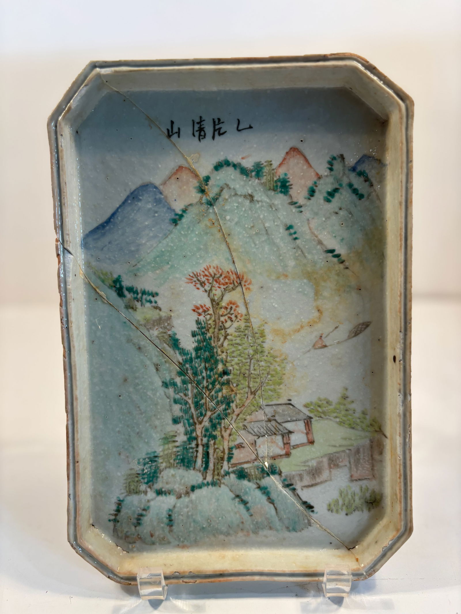 A Chinese Qianjiang hand painted porcelain tray: Qing Dynasty (1644-1912);Features a classic landscape scene with mountains, a scholar’s retreat, trees, and a boat.rectangular form with chamfered corners” . Dimensions?Length: 10 inches;