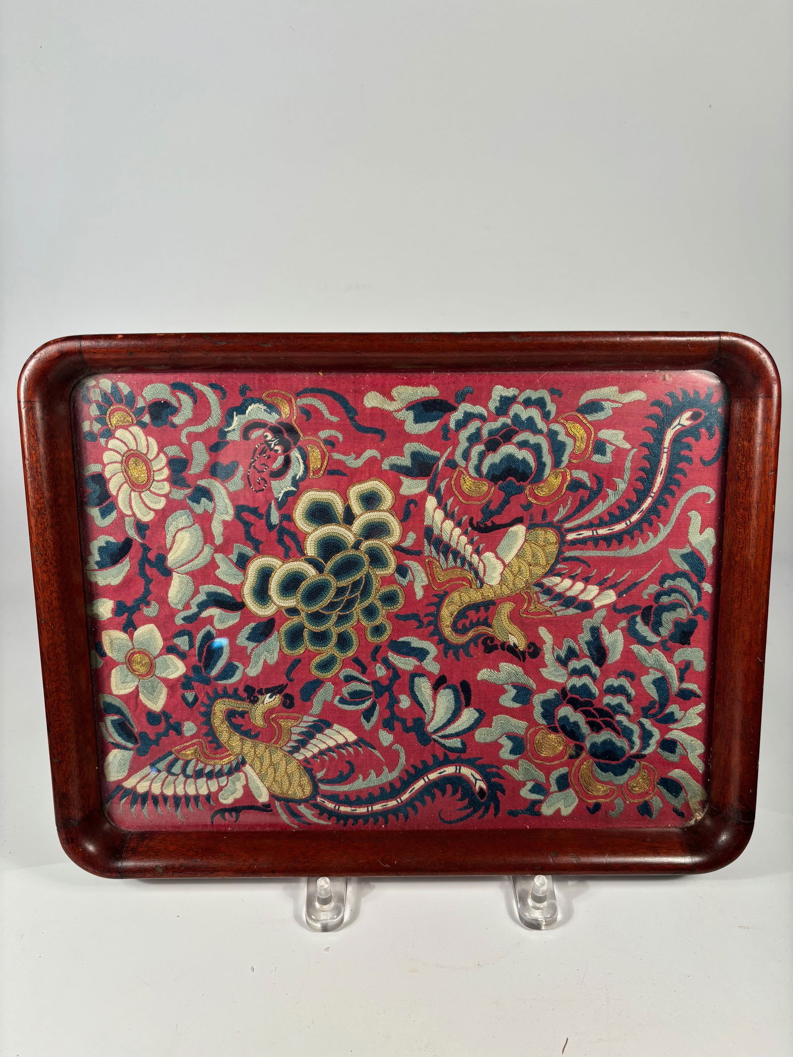 A Fine Chinese Silk Embroidery Fragment with Phoenix and Floral Motifs: Qing Dynasty(1644-1912); A rectangular Chinese lacquered wood tray featuring a vivid hand-embroidered silk panel inset to the base. The embroidery is finely worked with colorful silk and couched gold-
