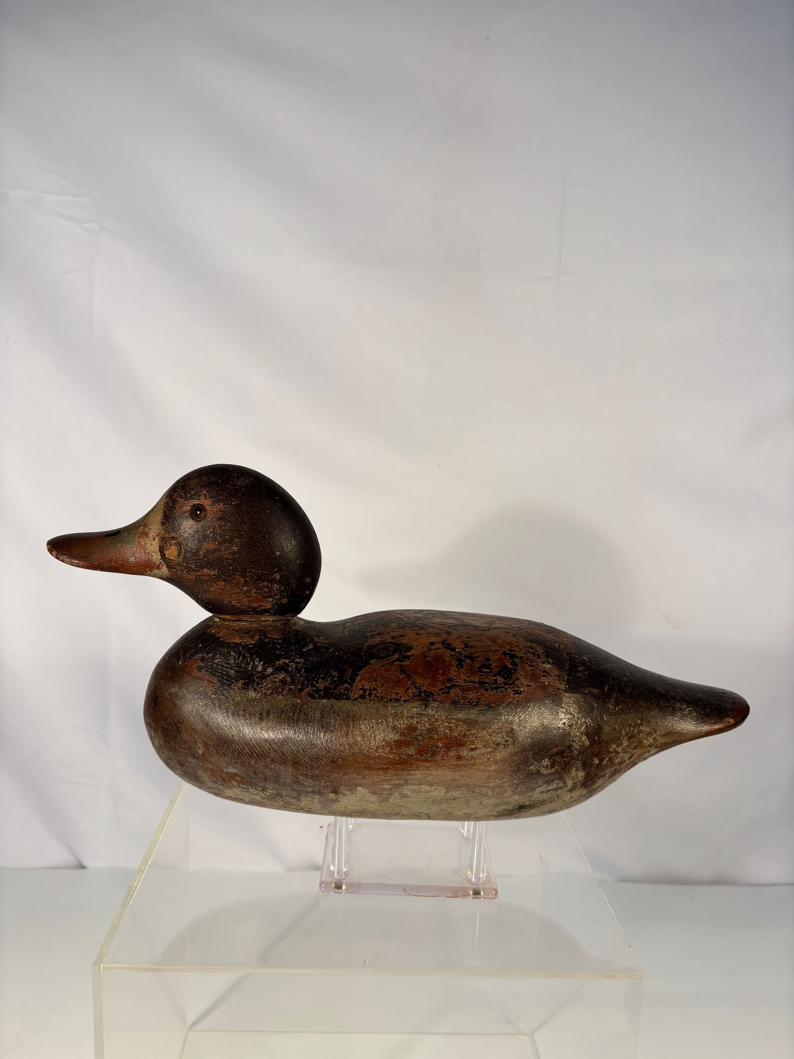 A Mallard Hen type Duck Decoy with “Raymond Lead?? Ballast: Early 20th Century; A carved and painted wooden working duck decoy, likely Massachusetts, early 20th century. The hollow body with separately carved head, painted in naturalistic tones, showing extens
