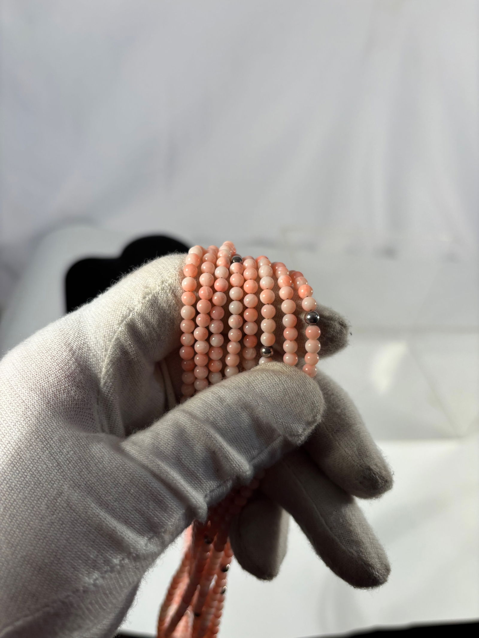 Eight-Strand Angel Skin Coral Bead Necklace: Eight-strand necklace composed of small round angel skin coral beads in soft pink tones, showing the natural color variation typical of coral. Finished with a silver-tone clasp. A classic multi-strand