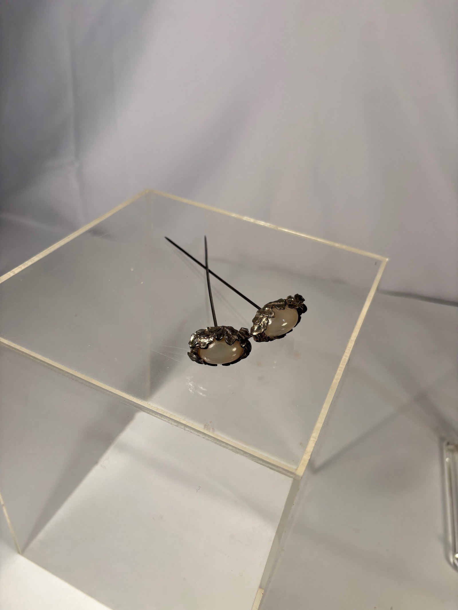 Pair of Silver-Mounted Moonstone Hairpins: 19th century, Pair of silver hairpins each set with an oval moonstone cabochon displaying soft adularescence. Traditional straight-pin form, suitable for hair ornamentation. Stones with natural intern