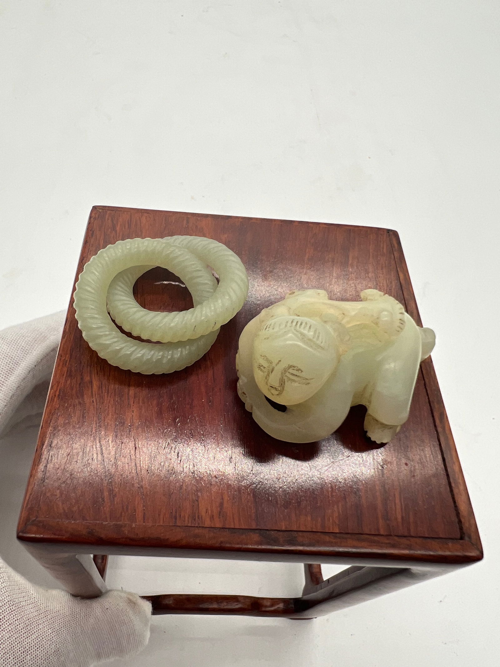 A Jade Boy Statue and two coiled circle Jade Ring: Qing dynasty (1644-1912);Dimensions? Ring length: 5 cm; Boy length: 4.2cm