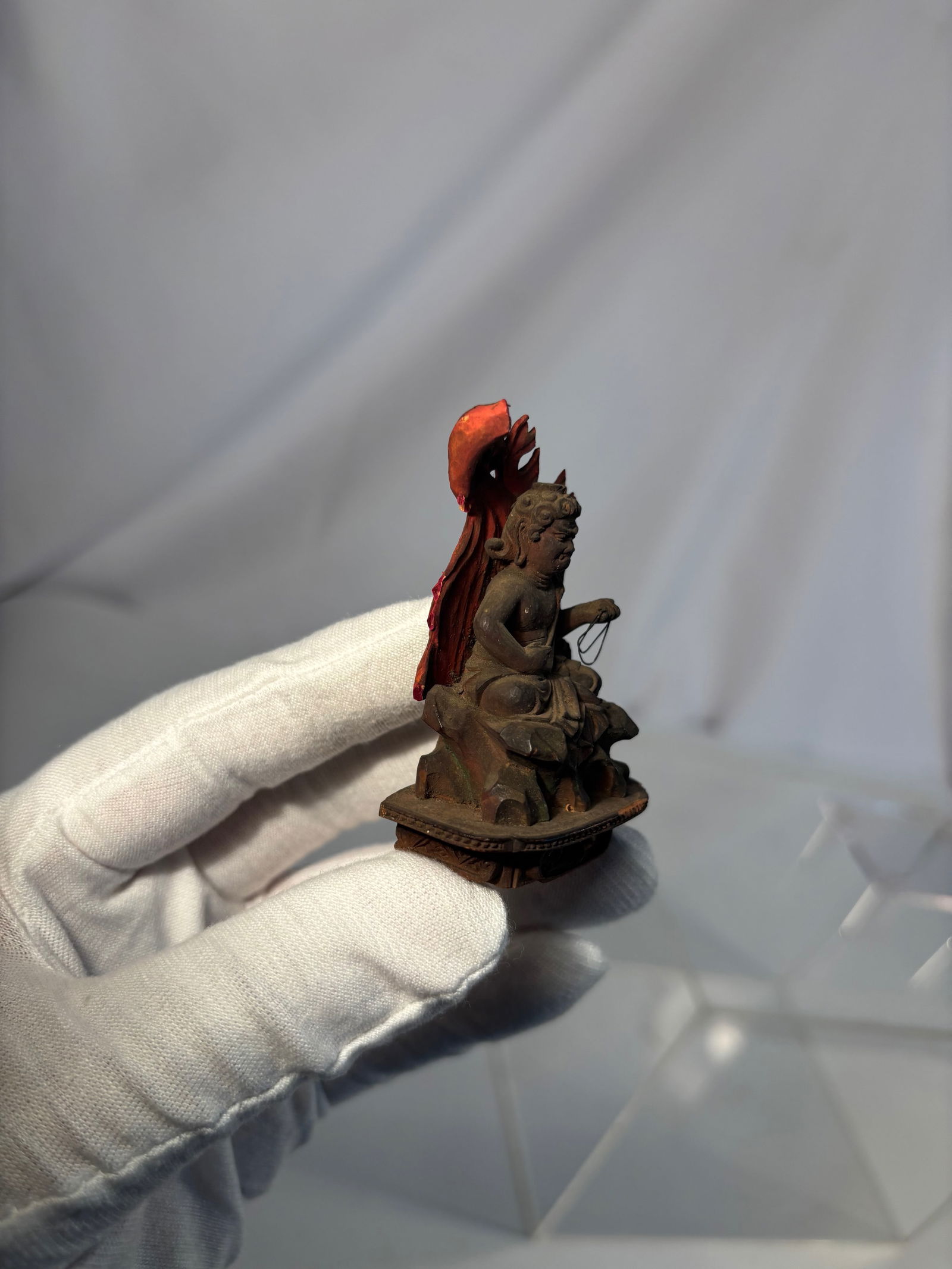 A Japanese Polychrome Wood Figure of Fud? My?: Edo period (1603-1868) ; Well-carved and painted in natural pigments, the wrathful deity is seated upon a rock base, holding a sword in his right hand and a coiled rope in his left, surrounded by a fl