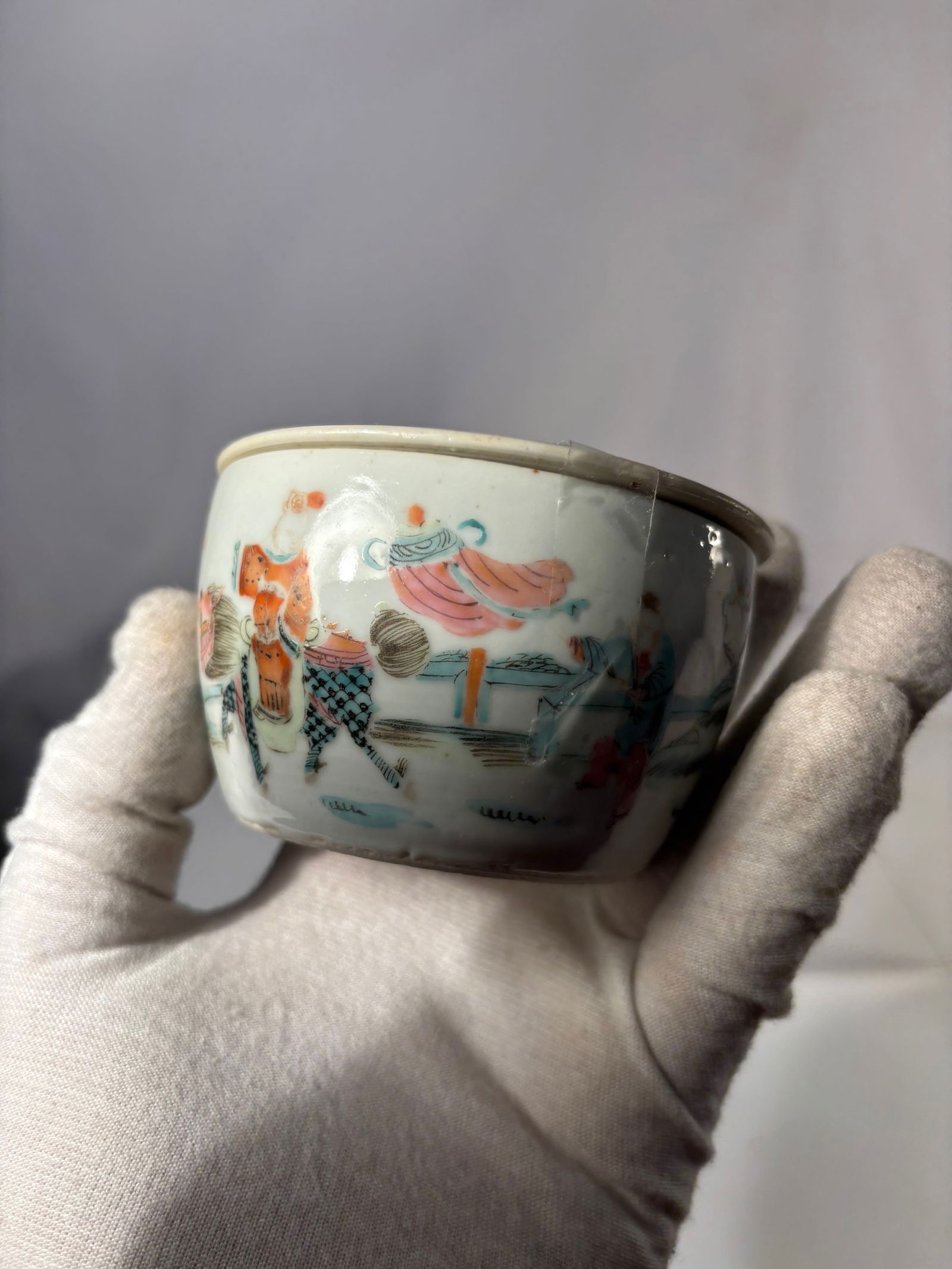 A Chinese Famille-Rose Porcelain Covered Bowl with Pierced Lid,: Qing dynasty(1644-1912); Of rounded form, the bowl finely enameled in soft famille-rose tones with a continuous scene of attendants and scholars in a garden terrace setting, detailed with pavilions, r