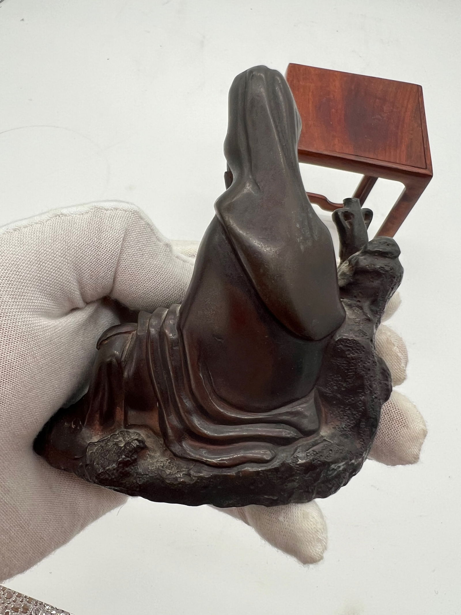 An Asian bronze Guanyin statue: 19th Century; The figure is seated on a naturalistic rocky base. The flowing robes and detailed adornments are typical of Guanyin or Buddhist figures. Dimensions?Height: 4 inches