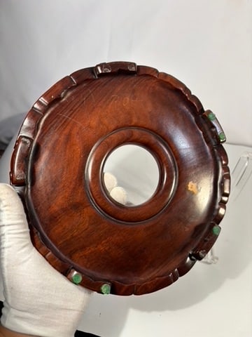 A Chinese Carved Rosewood Circular Display Stand: Chinese carved hardwood circular display stand, likely dating to the 20th century. The stand is finely carved with a raised central aperture designed to support a vase, bowl, or scholar’s object, su