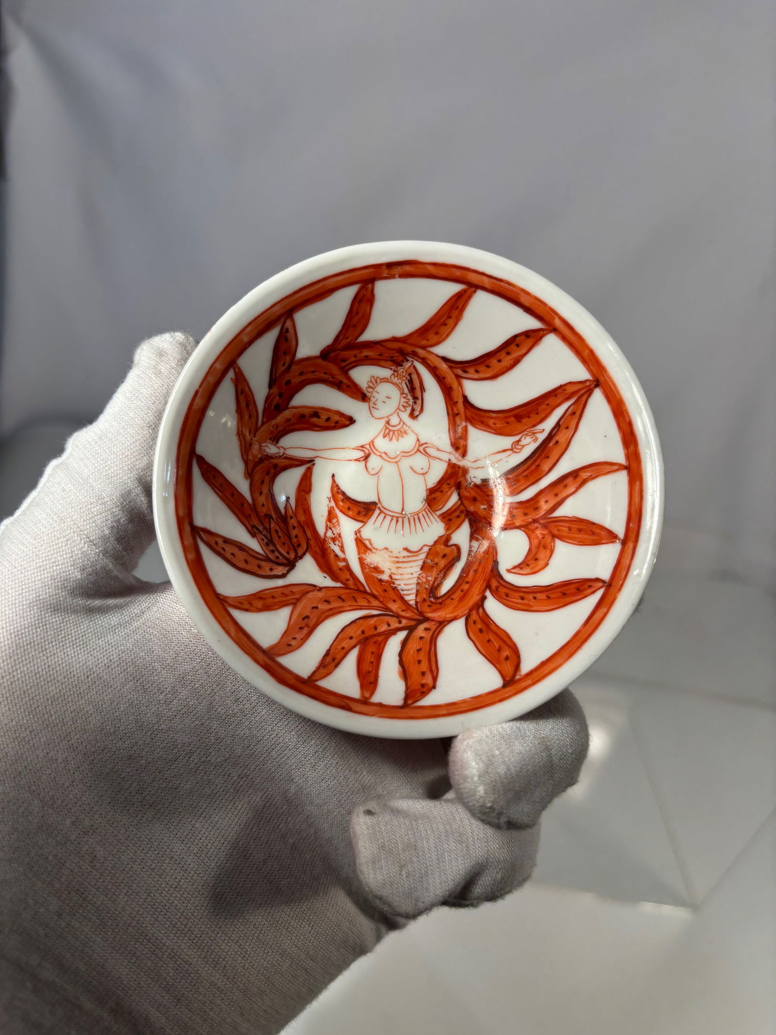 Chinese Iron Red Porcelain Bowl with Figural and Floral Decoration: 18th century, A Chinese porcelain bowl decorated in iron red with continuous figural and scrolling floral motifs around the exterior. The interior is plain white. The base is unglazed within the foot