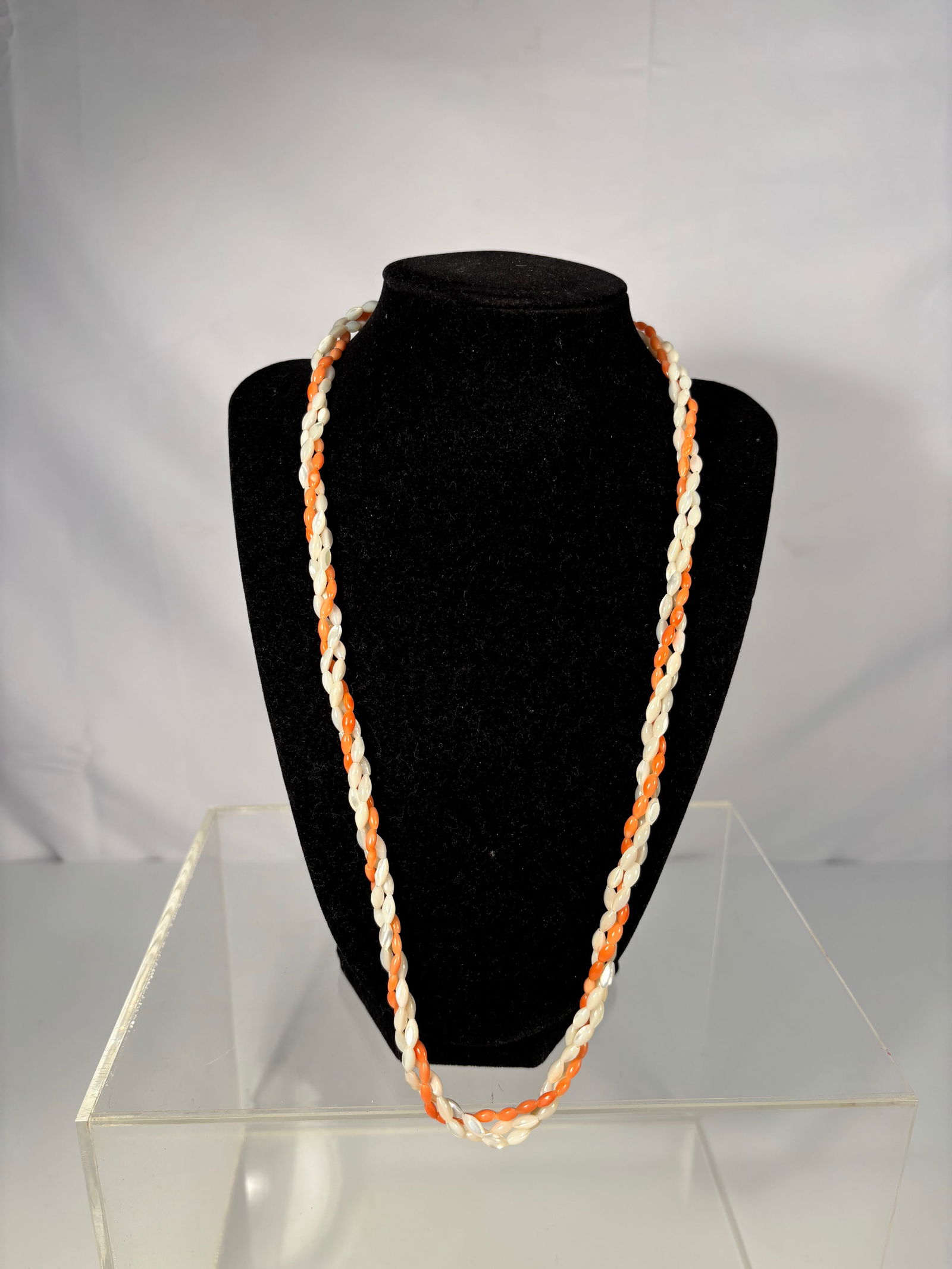 Twisted Strand Necklace of Coral and Tridacna (Ch?qú) Beads, Gold-Tone Clasp: A twisted rope-style necklace composed of alternating white Tridacna shell beads and salmon-orange coral beads, braided in two strands and secured with a gold-tone clasp. Dimensions?Length: 25 inches.