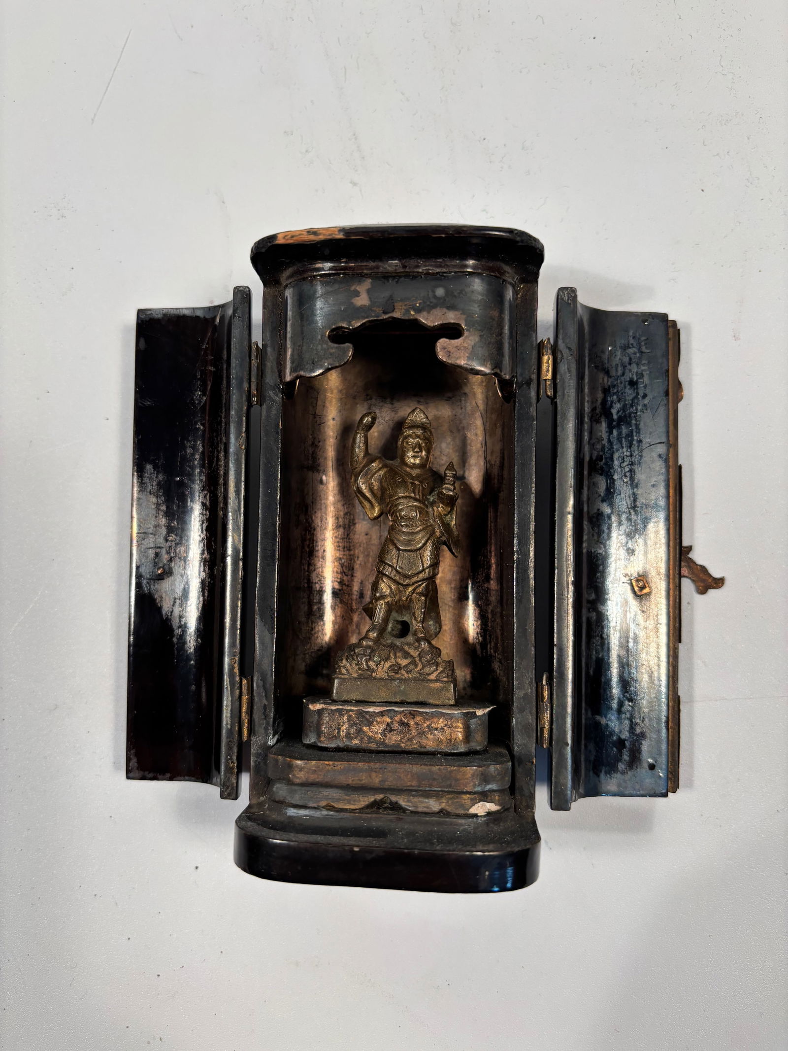 A Japanese Buddhist Zushi Shrine: 19th Century, Buddhist Zushi Shrine , composed pf a black and gold lacquered wood zushi, housing a standing bronze goddess statue. Dimensions?Height: 5 inches