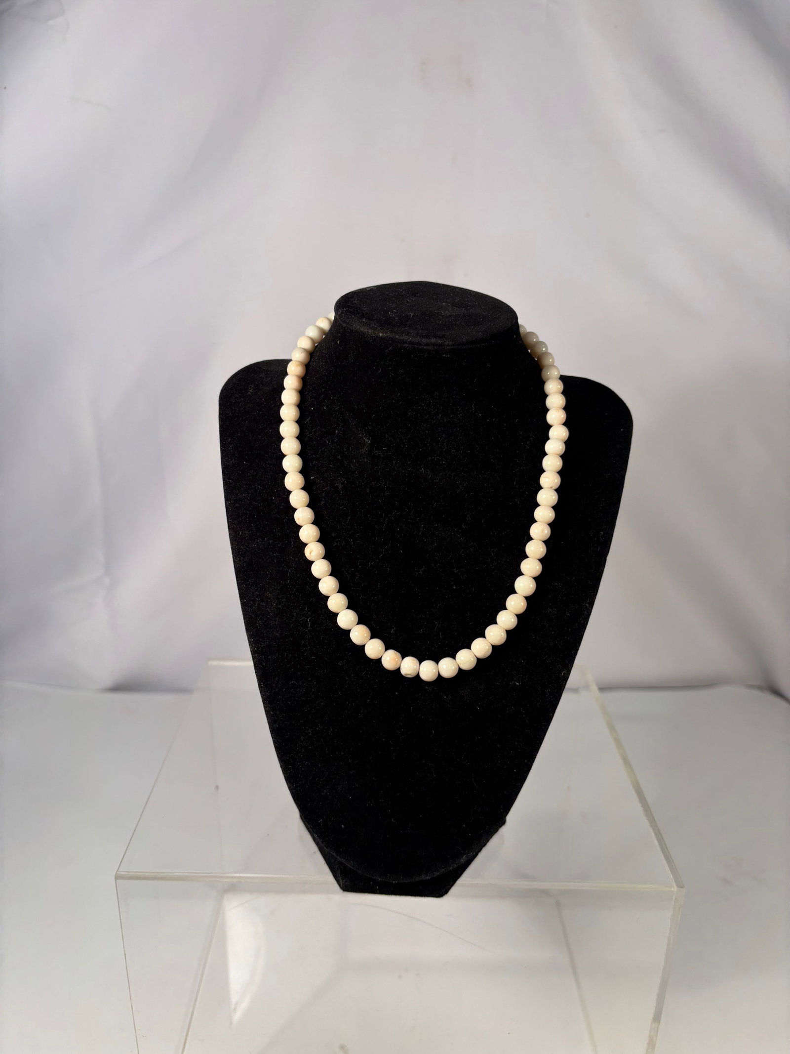 A Vintage White Coral Bead Necklace: A vintage strand of natural white coral beads, featuring a soft creamy tone and finely granular surface typical of coral calcium structure. Strung as a single necklace and fitted with a gold-tone spri