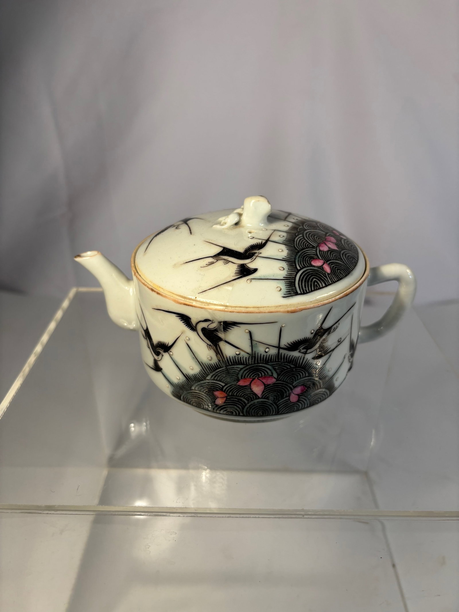 A Chinese Famille-Noire Porcelain Covered teapot: Qing Dynasty, 19th Century; Of rounded form with loop handle and short spout, surmounted by a domed cover with bud-form finial, delicately enamel-painted in the famille-noire palette with swallows fly