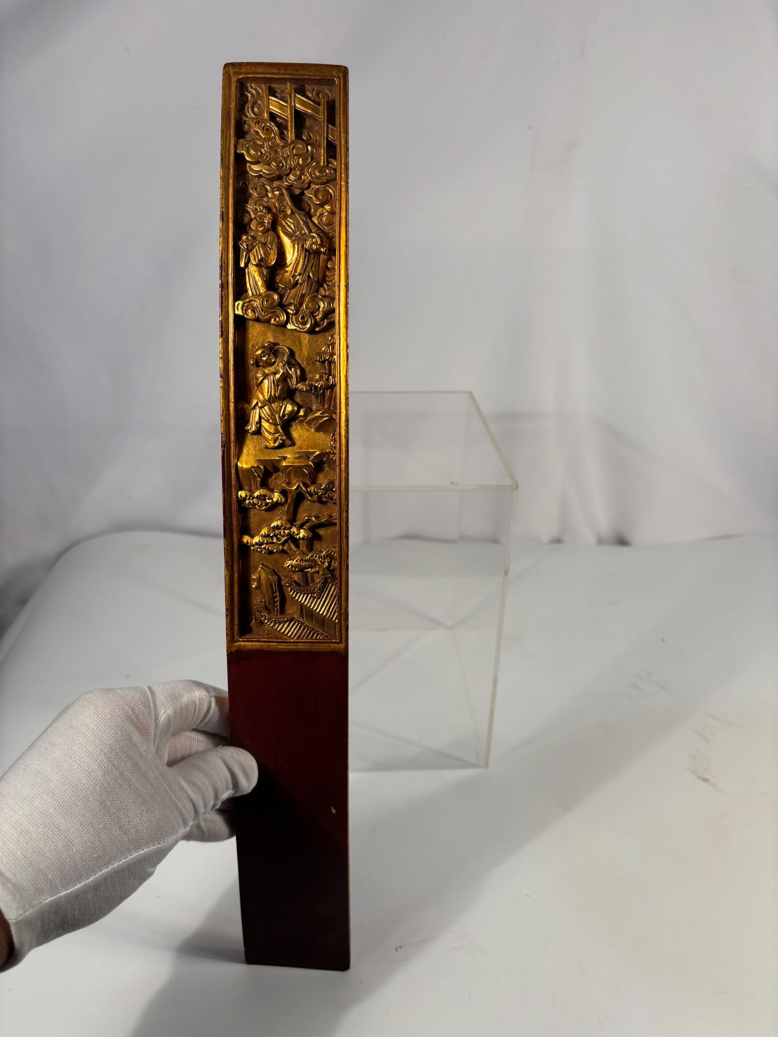 A Chinese Gilt and Lacquered Wooden Court Tablet (Hu Board): Qing dynasty(1644-1912); A finely carved and gilt-lacquered wooden Hu board (court tablet), featuring tiered relief scenes of robed figures among swirling clouds, rocky terraces, and pine trees. The e