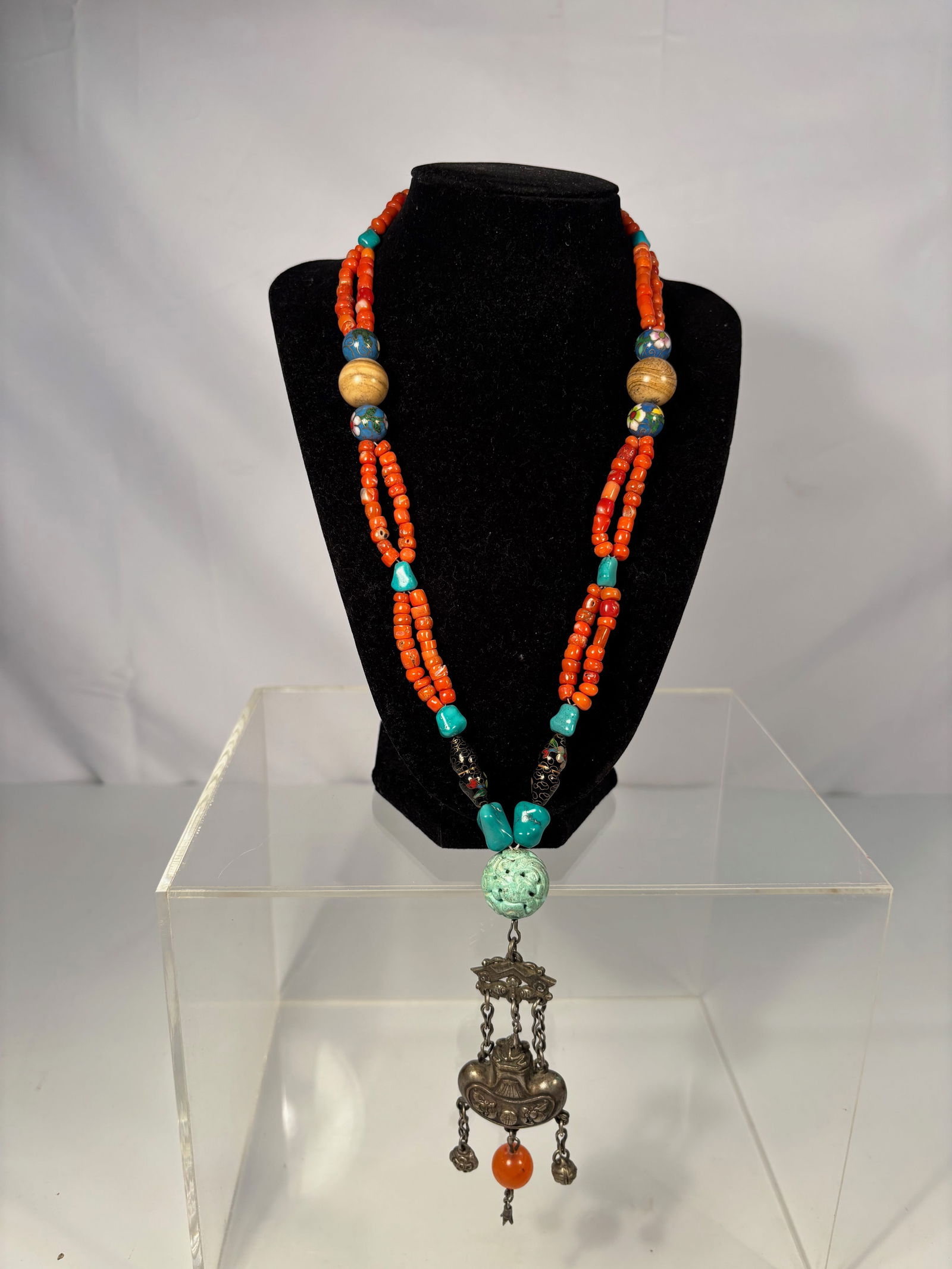 Chinese Coral Necklace with Carved Turquoise Bead and Silver Longevity Lock Pendant: Qing Dynasty(1644-1912), A Chinese double-strand necklace composed of natural red coral beads interspersed with rough turquoise nuggets and cloisonné floral enamel spacers. The centerpiece features a