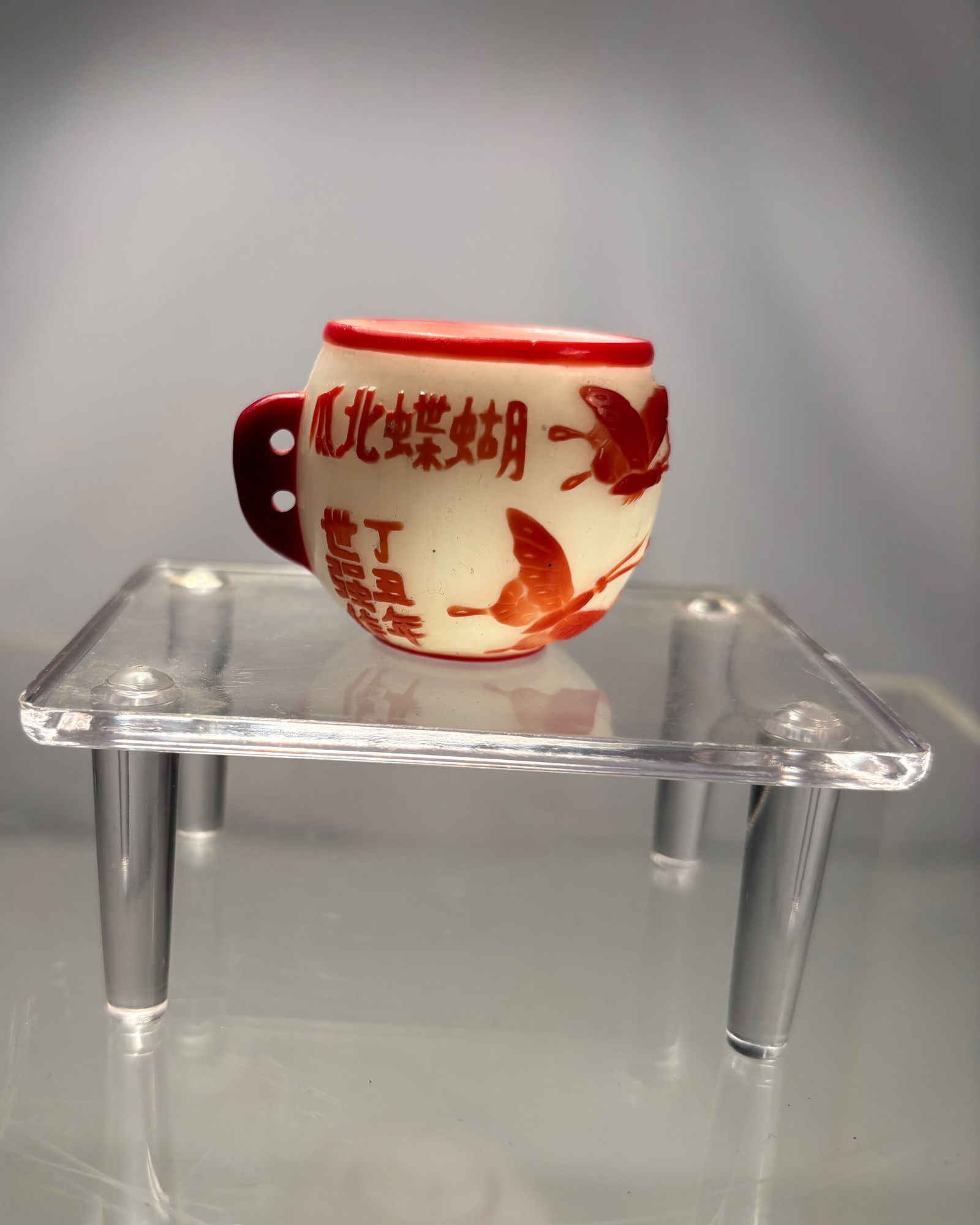 A Chinese Glass Bird Food Jar Signed and Dated: Qing dynasty(1644-1912); Chinese glass bird food jar, of rounded form with a narrow mouth and twin lug handles for suspension within a birdcage. Decorated in red with floral motifs and auspicious insc