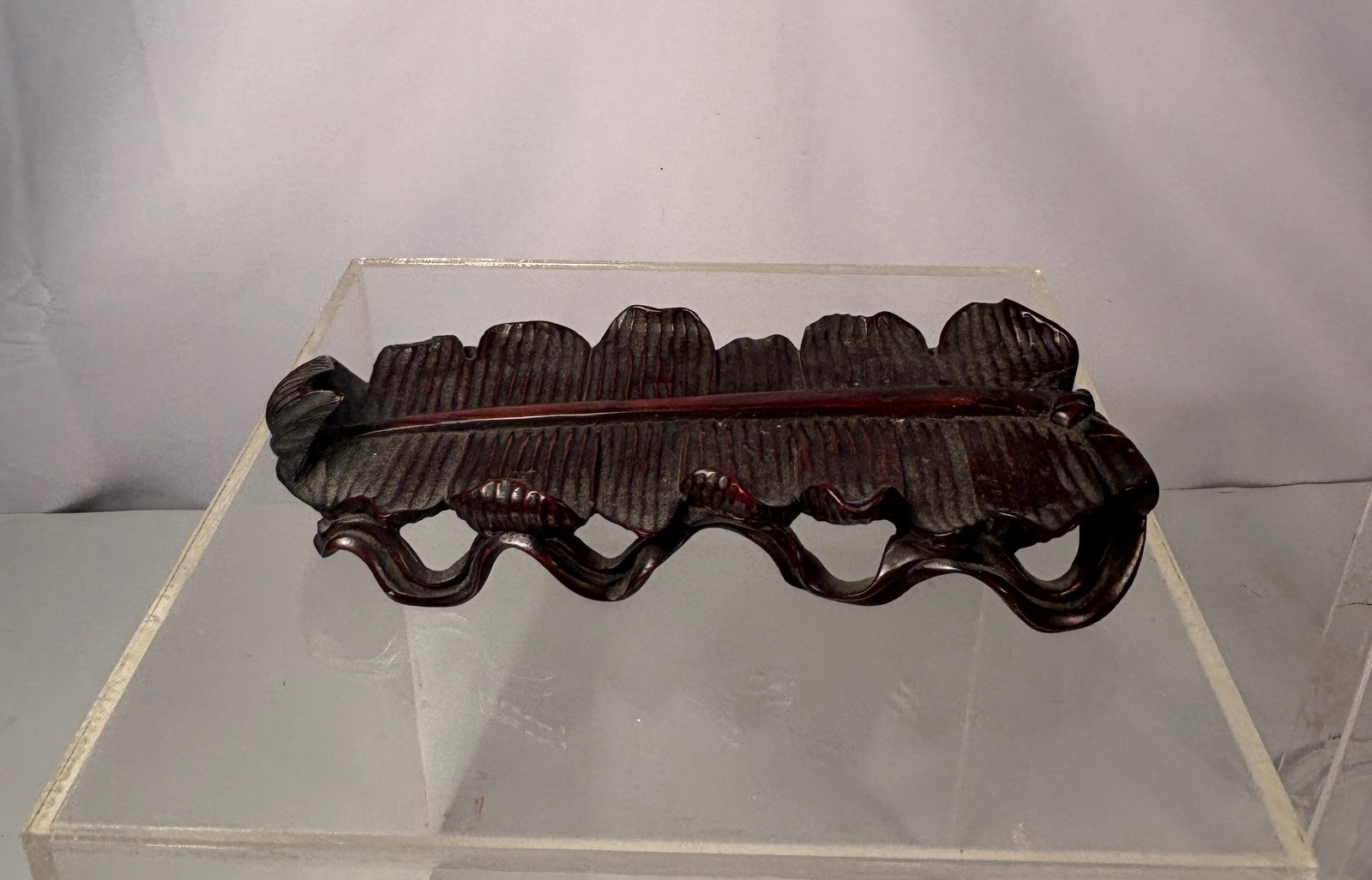A Chinese Carved Rosewood Leaf-Form Ornament Stand: Qing Dynasty (1644-1912); A Chinese carved Rosewood leaf-form Stand, finely carved in high relief with dense, parallel veins and undulating edges, realistically modeled after a natural leaf. The carvi