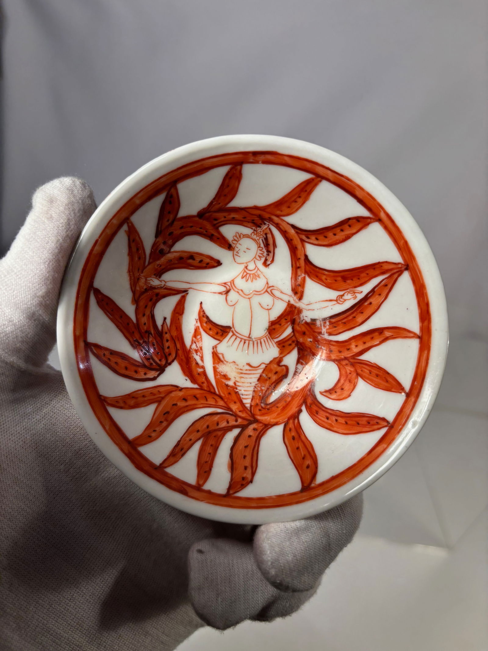 Chinese Iron Red Porcelain Bowl with Figural and Floral Decoration: 18th century, A Chinese porcelain bowl decorated in iron red with continuous figural and scrolling floral motifs around the exterior. The interior is plain white. The base is unglazed within the foot