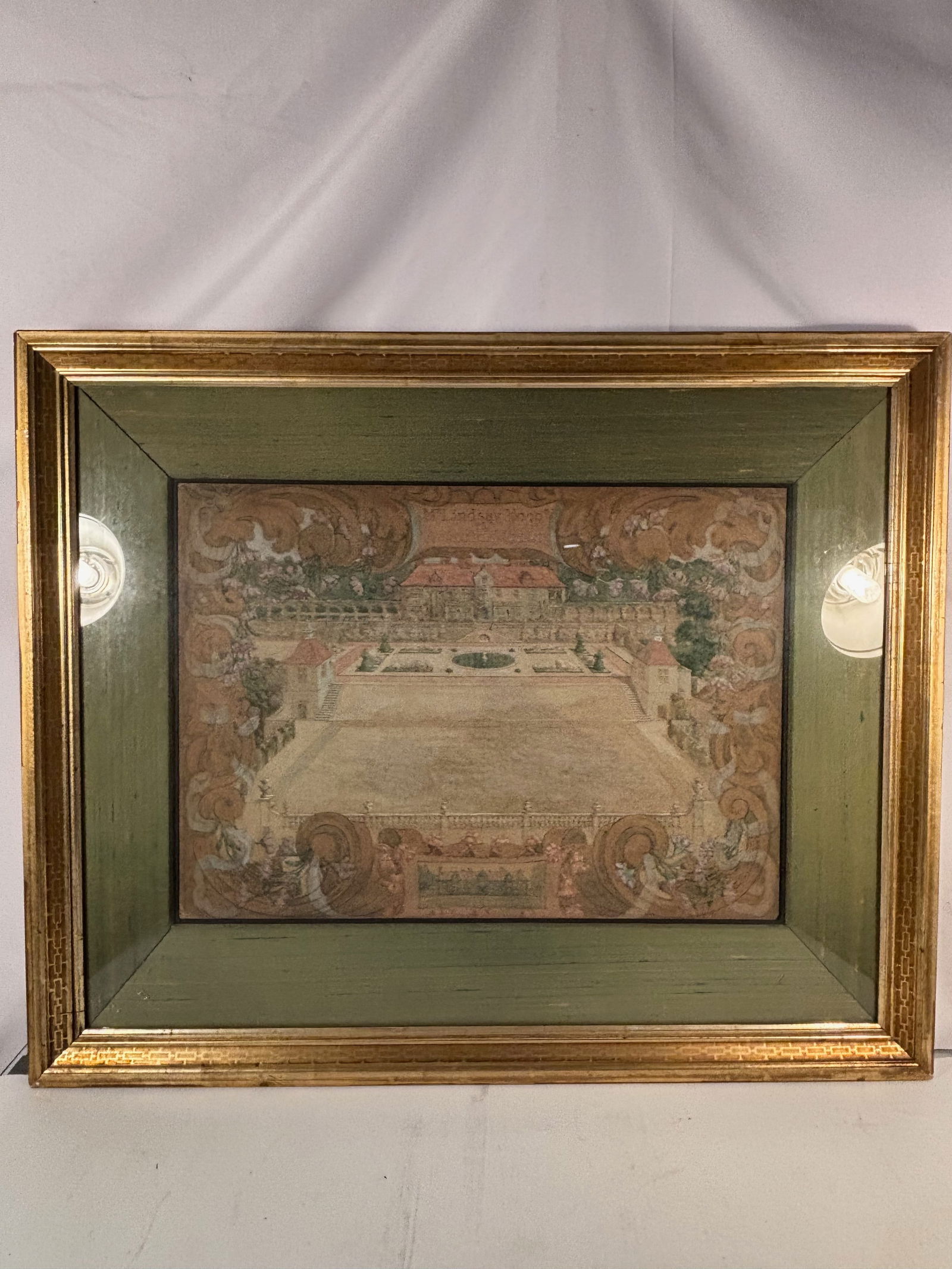 Mr. Lindsay Hogg’s at Rotherfield, Sussex , Unknown British artist ,Circa 1890 – 1910: A detailed bird’s-eye watercolor of a country manor and formal gardens, with terraces, fountains, and ornamental topiary framed within elaborate scrollwork and floral decoration. The ornamental cart