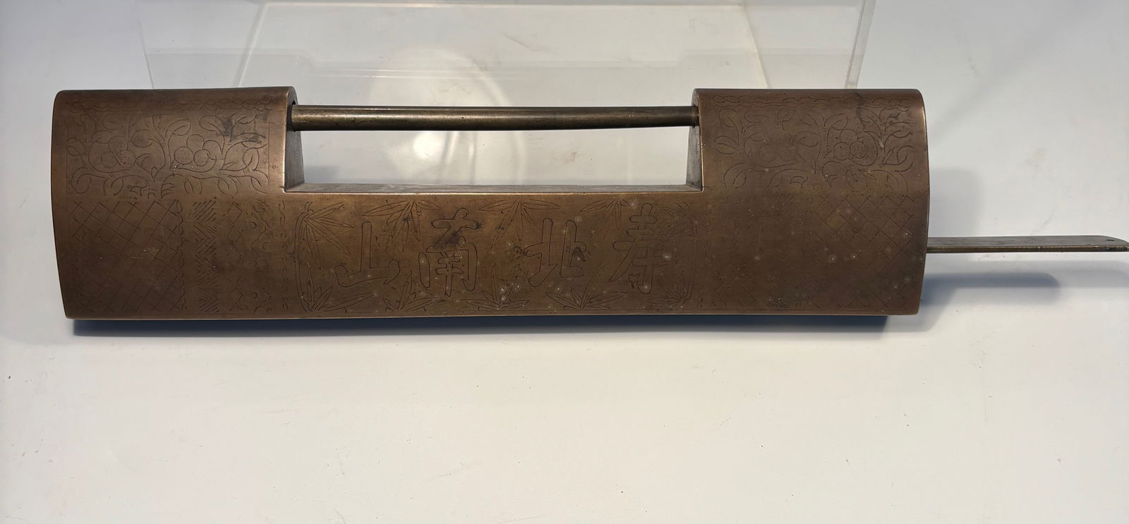 A Heavy Chinese Bronze Lock Engraved with Chinese Characters, 13.5 inches long: Qing dynasty(1644-1912);A finely crafted antique Chinese brass lock of elongated rectangular form, delicately engraved with floral and geometric motifs . The lock mechanism slides smoothly with a matc