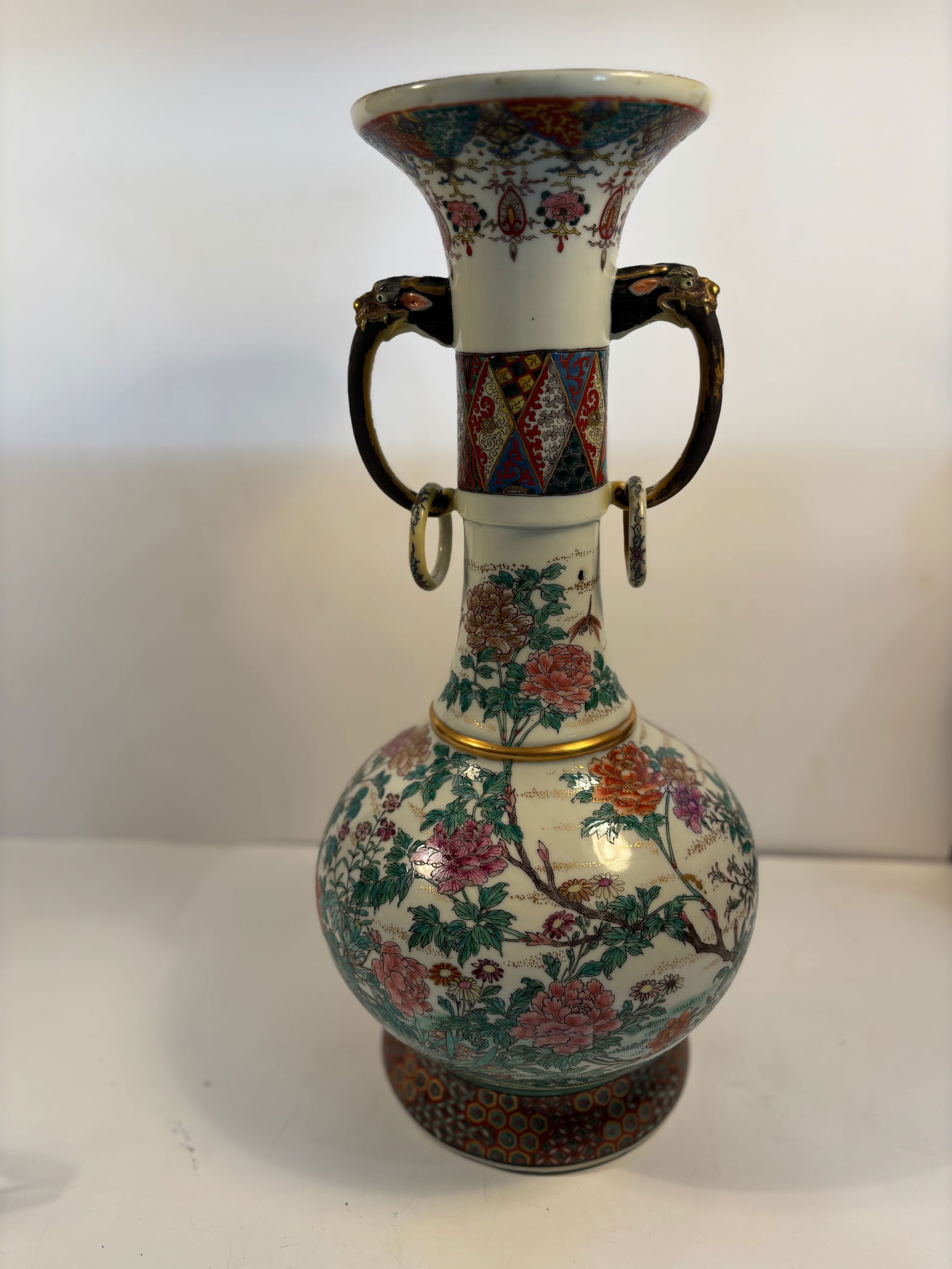 A Large Japanese Satsuma-Style porcelain Vase with two handles and rings: late Meiji to Taish? period (circa 1890–1920s);Delicate overglaze enamel floral decoration with fine gold detailing. Dimensions?Height: 19.5 inches; Width: 9.5 inches.