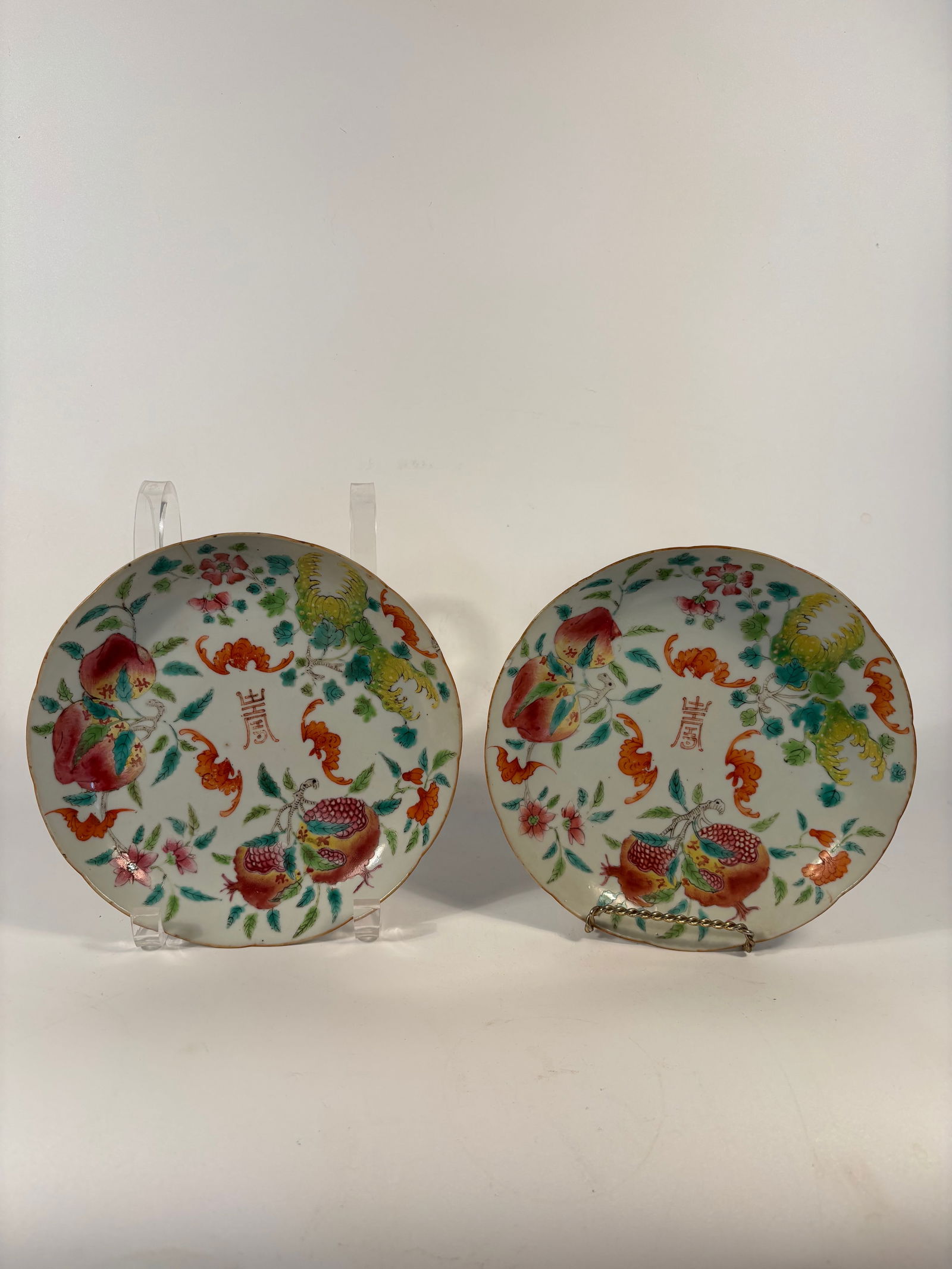 Pair of Chinese famille rose porcelain dishes with "CHENGHUA" mark: Qing dynasty(1644-1912);The plates feature auspicious motifs — pomegranates, phoenixes, bats, and flowers, symbolizing fertility, blessings, and prosperity.Central character “Shou” for longe